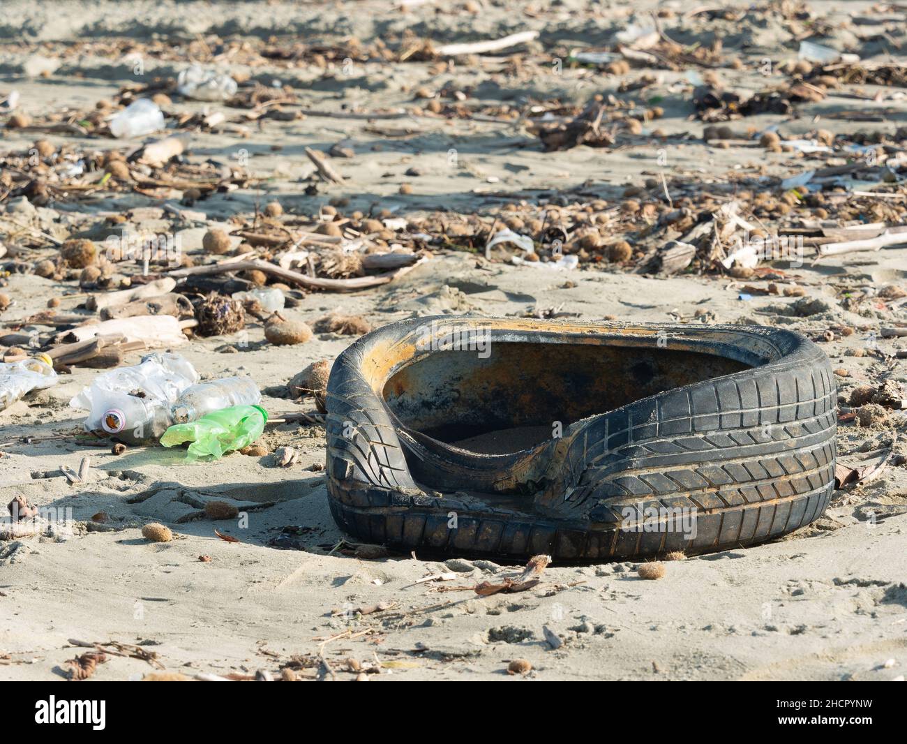 Pneumatici, bottiglie di plastica e altri rifiuti lasciati sulla spiaggia dopo una tempesta, un simbolo di grave inquinamento dei mari e degli oceani Foto Stock