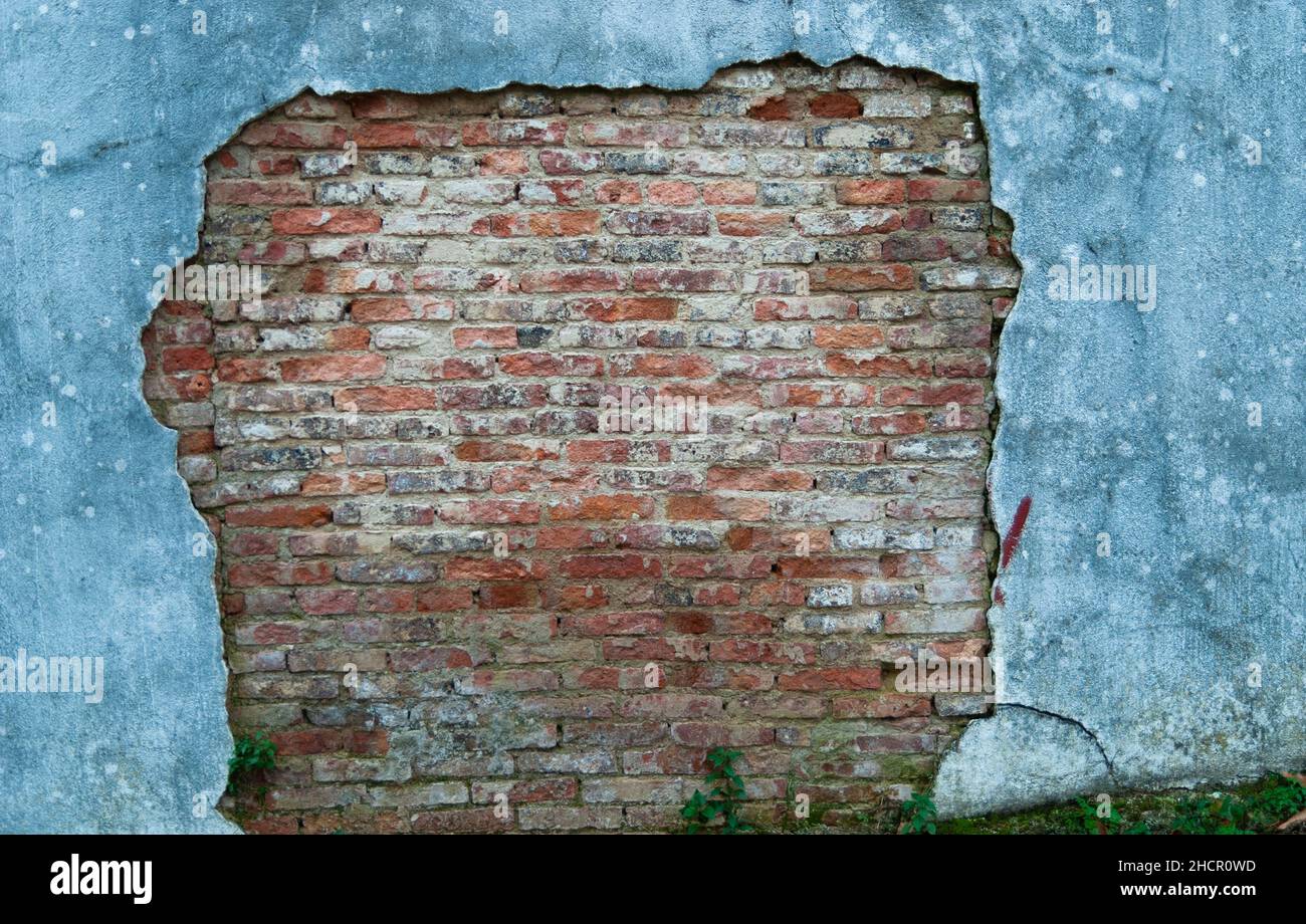 muro rotto di colore bianco sporco con vista del vecchio mattone rosso e grigio di diverse sfumature per carta da parati o sfondo orizzontalmente Foto Stock