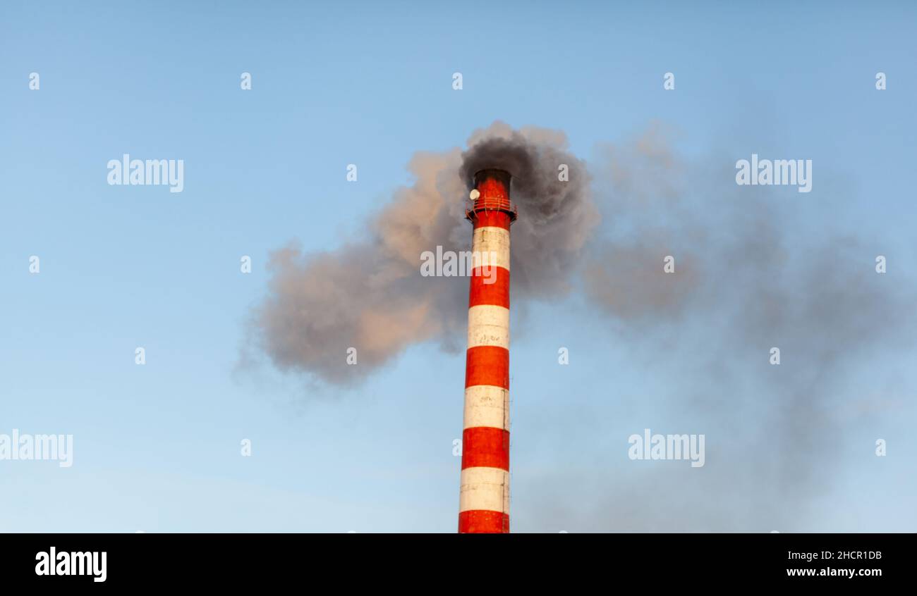Fumo bianco spesso dal camino del locale caldaia. Fumo contro il cielo blu. Inquinamento atmosferico. Riscaldamento della città. Zona industriale. Foto Stock