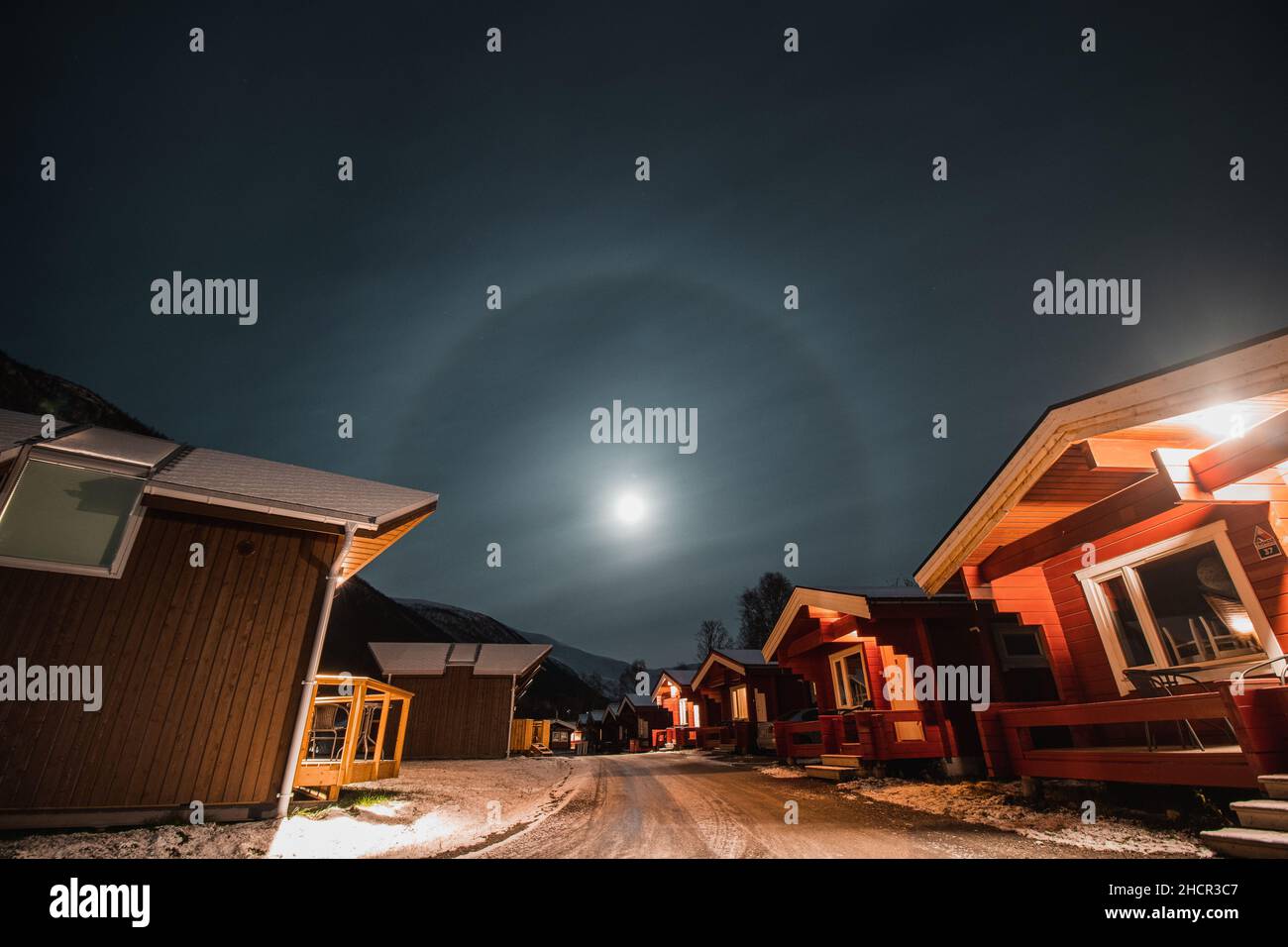 L'effetto alone della luna nella città norvegese settentrionale di Tromso tra le tipiche capanne rosse. Una luna che sospira, lontano dal Circolo polare Artico. Foto Stock