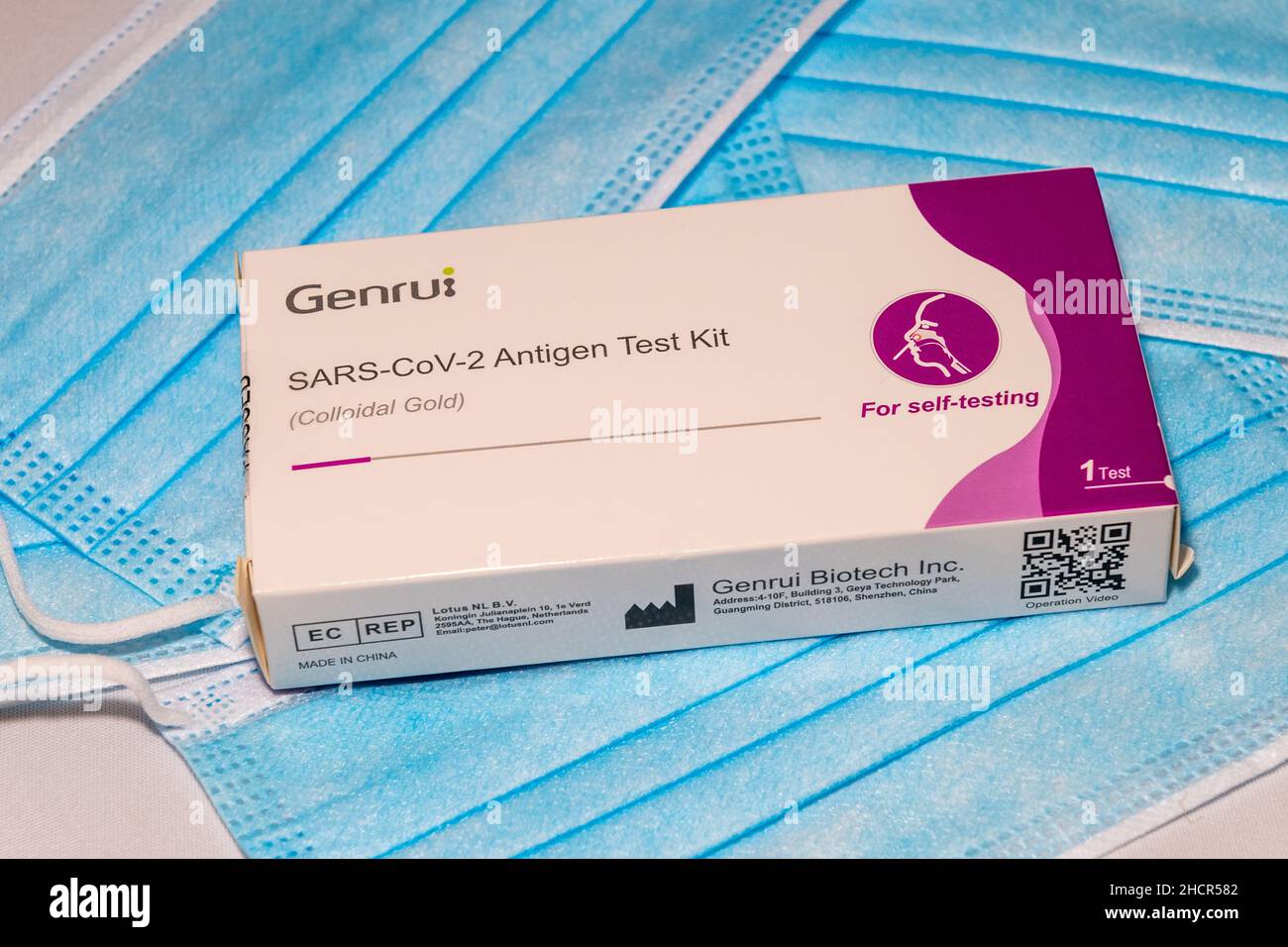 Kit per test antigene Genrui COVID-19 posizionato su maschere facciali. Foto Stock