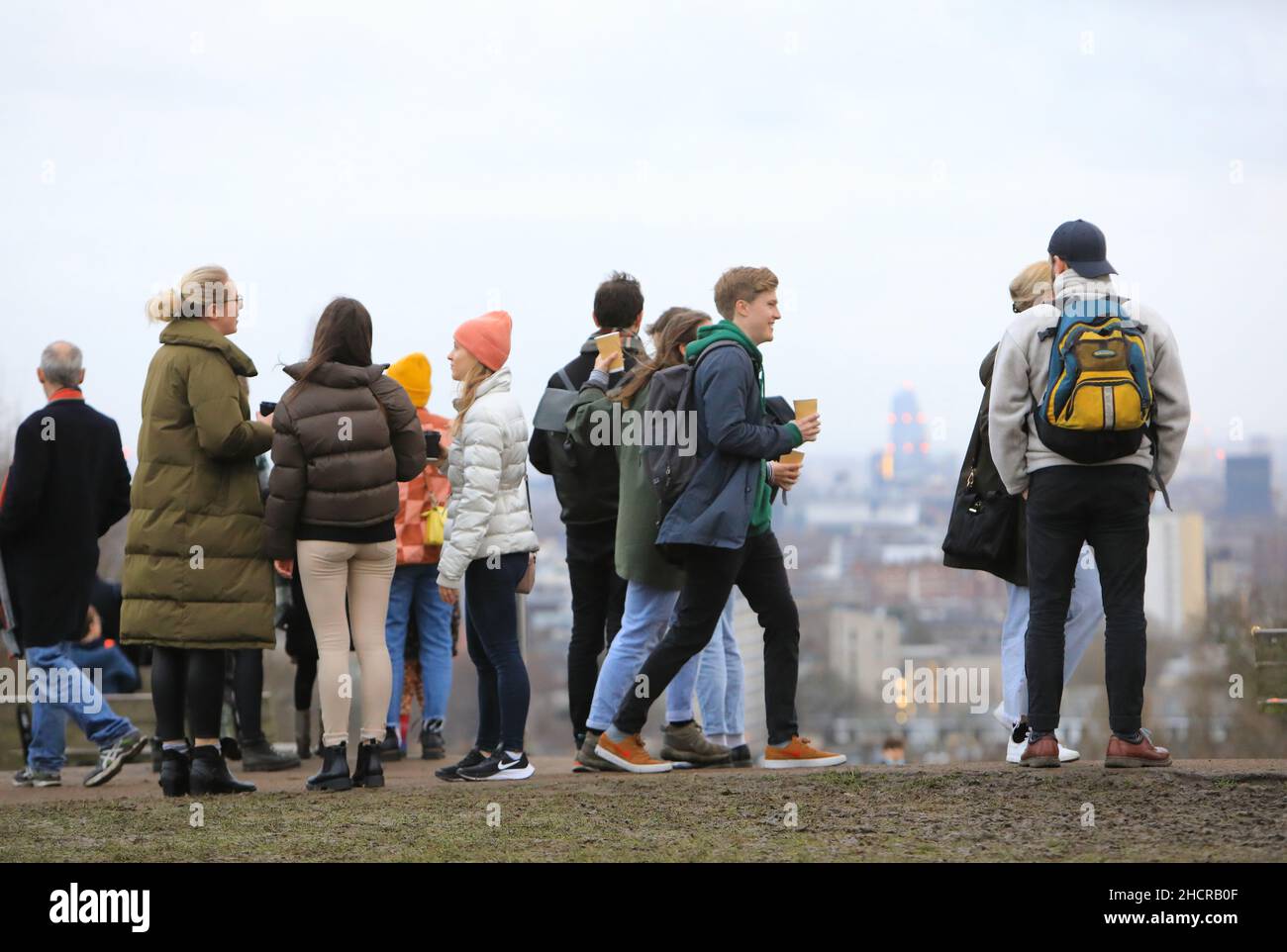 Londra, Regno Unito, dicembre 31st 2021. Le temperature primissime di 15 gradi tentarono un sacco di escursionisti fuori al Parliament Hill Fields a Hampstead Heath nel nord di Londra con vista verso la città. Era ancora nuvoloso dopo uno dei Decembers più nulli dal 1956. Credit: Monica Wells/Alamy Live News Foto Stock