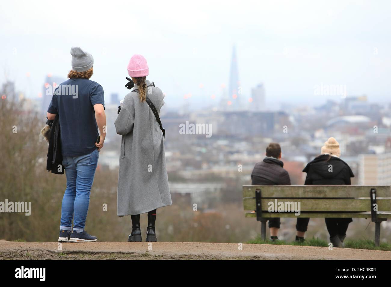 Londra, Regno Unito, dicembre 31st 2021. Le temperature primissime di 15 gradi tentarono un sacco di escursionisti fuori al Parliament Hill Fields a Hampstead Heath nel nord di Londra con vista verso la città. Era ancora nuvoloso dopo uno dei Decembers più nulli dal 1956. Credit: Monica Wells/Alamy Live News Foto Stock
