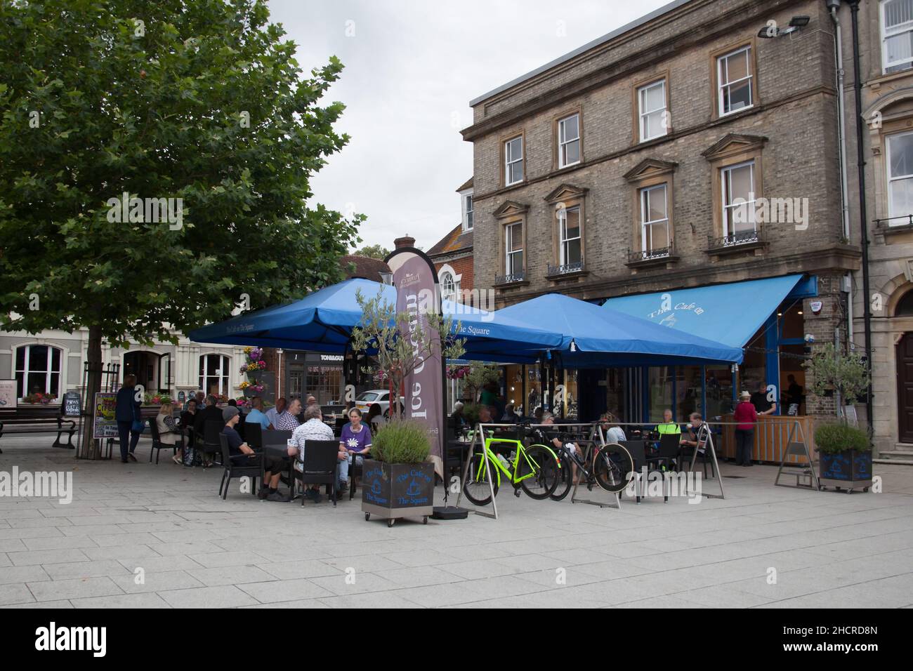 Vista sulla strada a Wimborne Minster con persone seduti su una terrazza a Dorset, nel Regno Unito Foto Stock