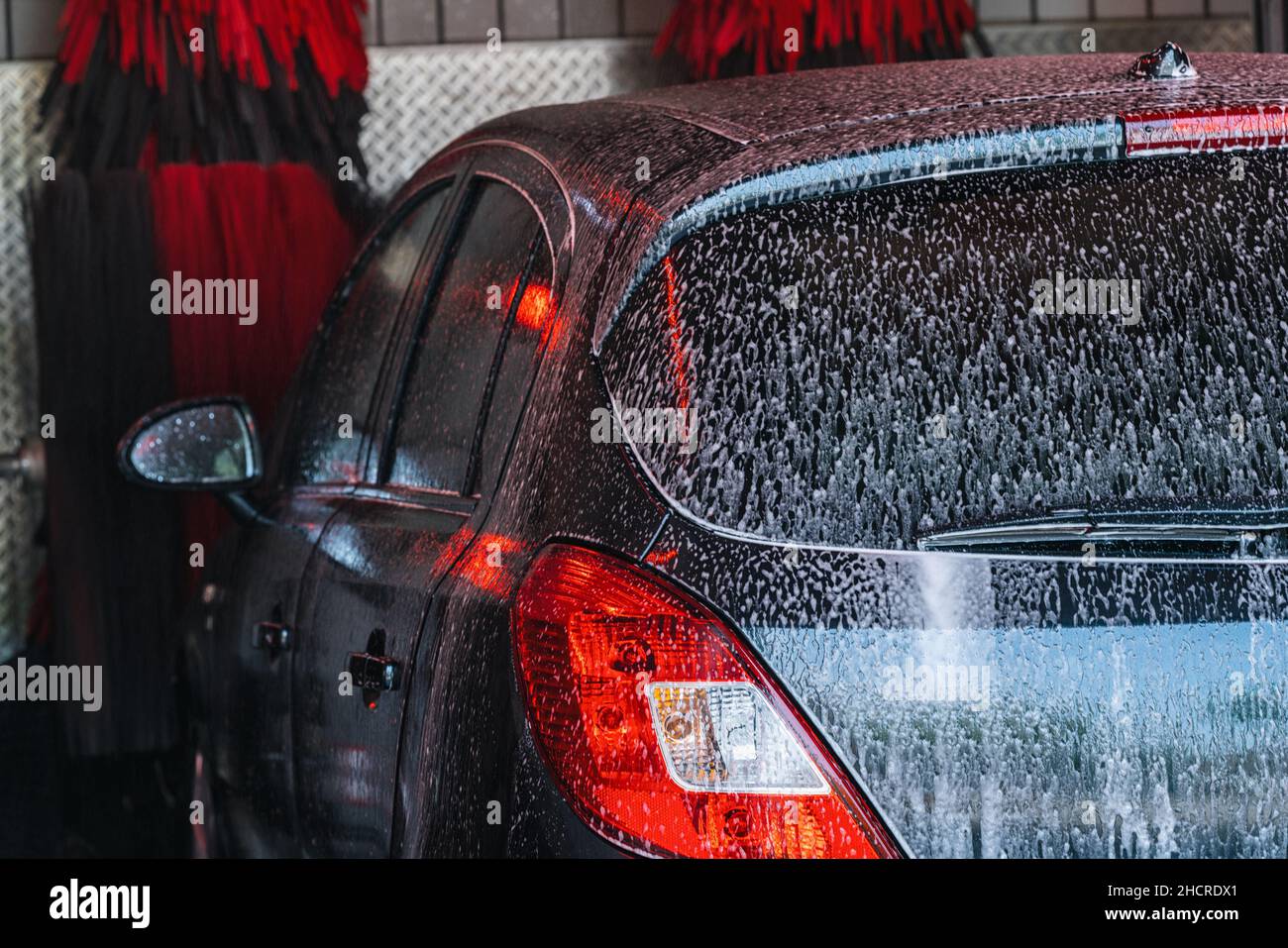 Acqua in schiuma per autolavaggio, autolavaggio automatico in azione Foto Stock