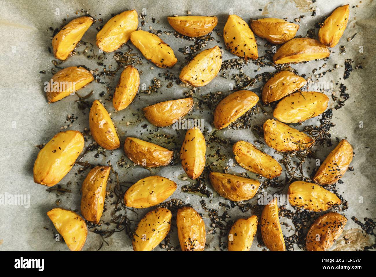 Fette di patate al forno con rosmarino e olio - verdure biologiche fatte in casa vegano vegetariano patate spicchi snack pasto. Foto Stock