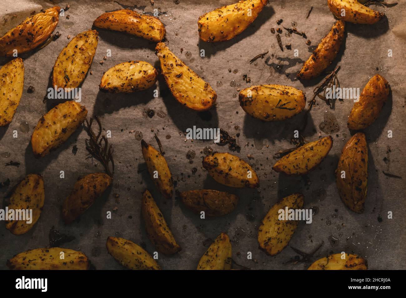 Fette di patate al forno con rosmarino e olio - verdure biologiche fatte in casa vegano vegetariano patate spicchi snack pasto. Foto Stock