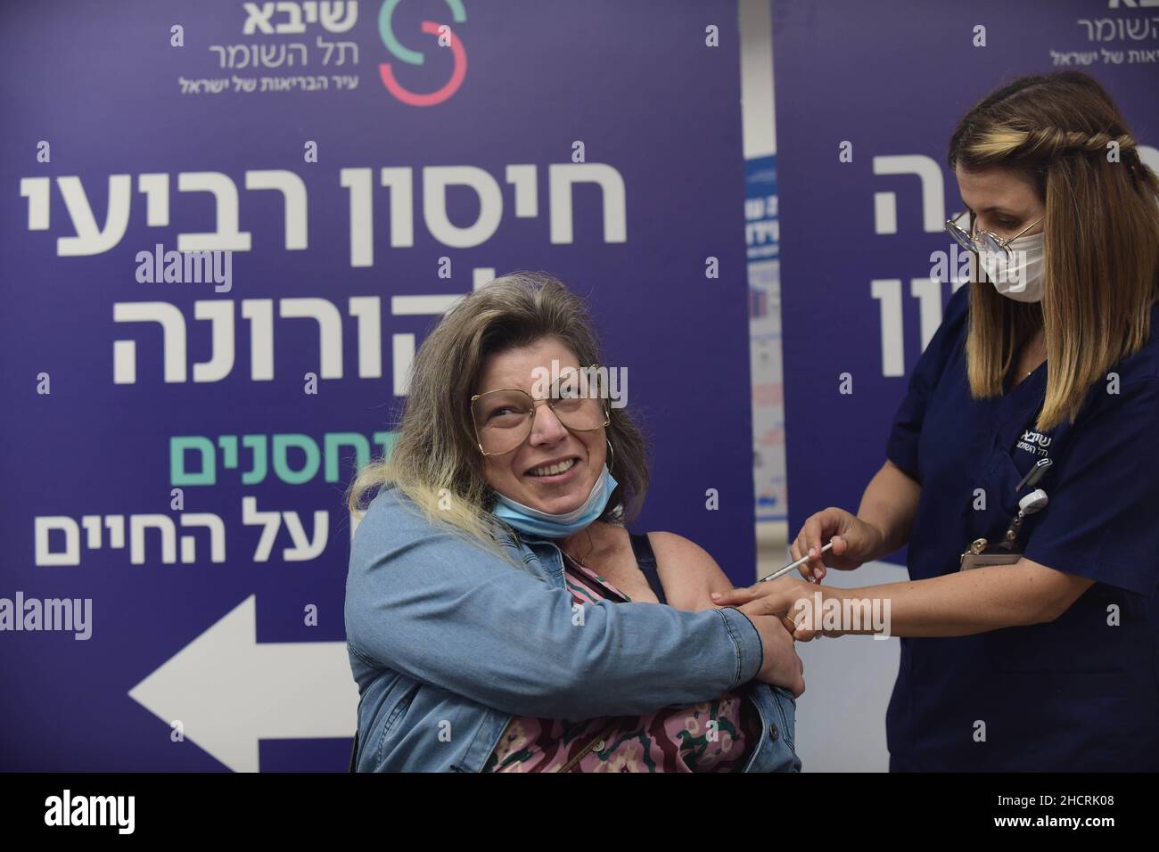 Ramat Gan, Israele. 31st Dic 2021. (211231) -- RAMAT GAN (ISRAELE), 31 dicembre 2021 (Xinhua) -- Una donna riceve la sua quarta dose del vaccino COVID-19 presso lo Sheba Medical Center di Ramat Gan, Israele centrale, il 31 dicembre 2021. Il Ministero della Sanità israeliano ha dichiarato di aver approvato la somministrazione del quarto vaccino di richiamo sparato contro COVID-19 per i residenti e il personale delle case di cura. (Tomer Neuberg/JINI via Xinhua) Credit: Xinhua/Alamy Live News Foto Stock