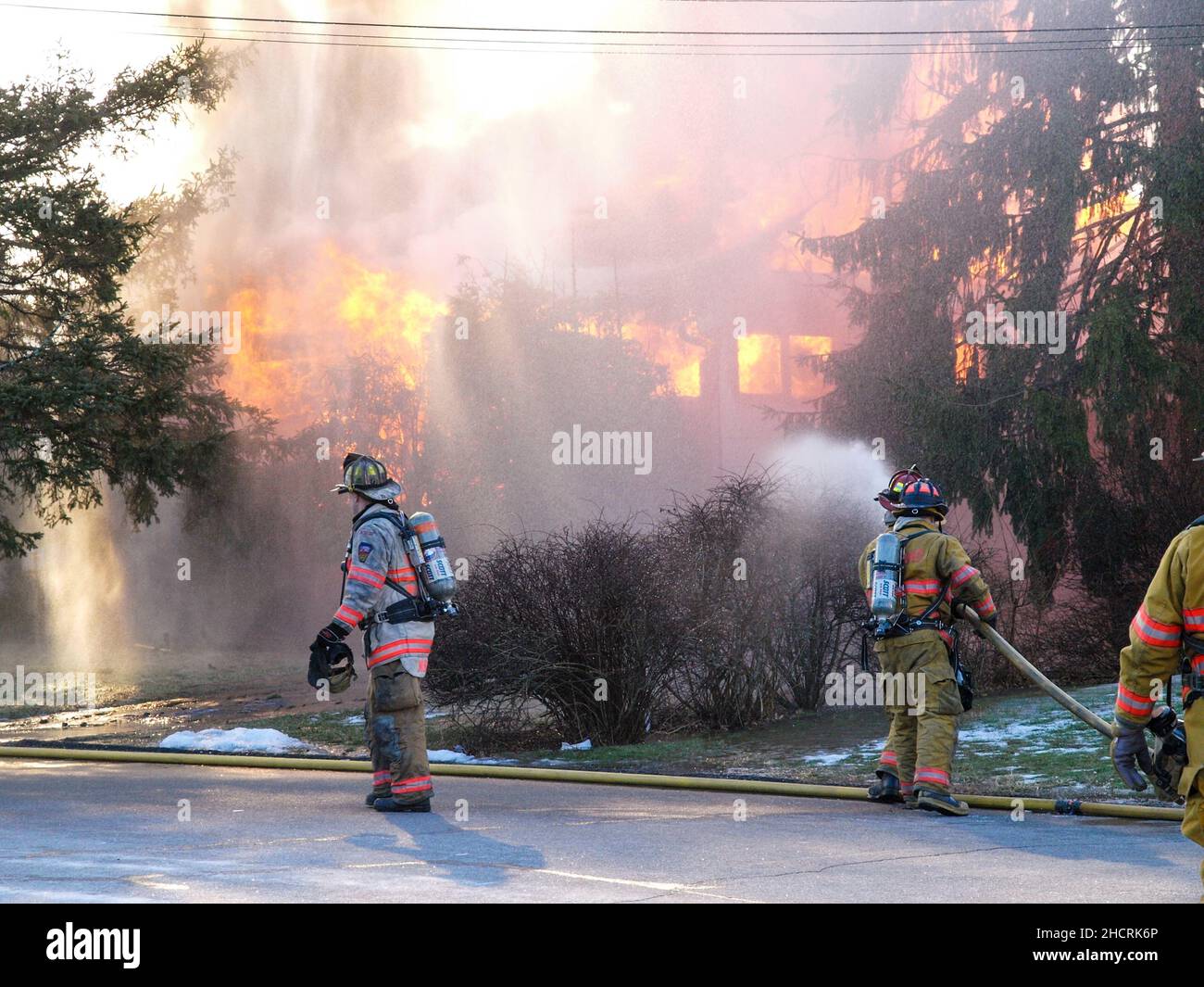 Vigile del fuoco al fuoco di lavoro con fiamme drammatiche Foto Stock