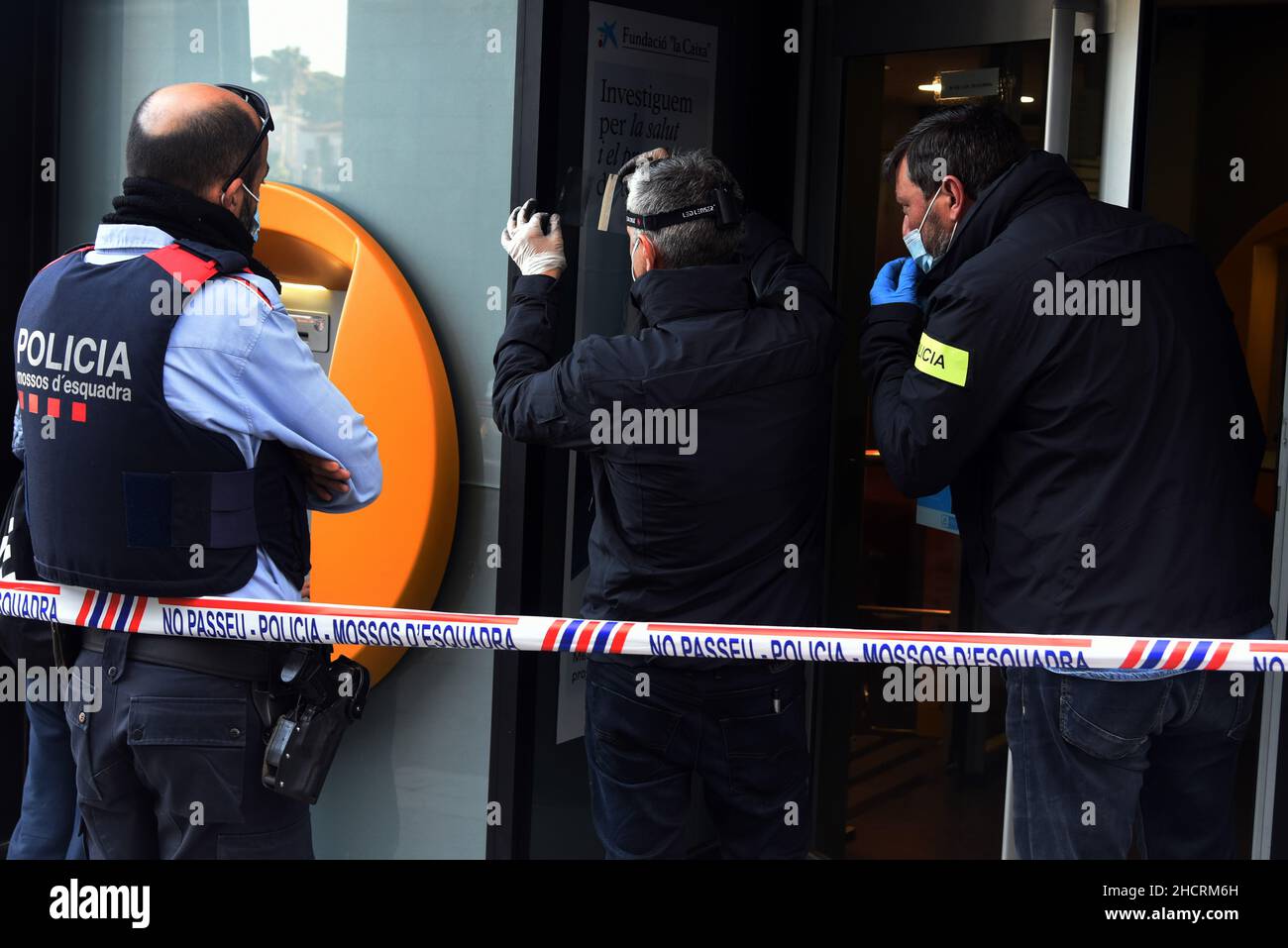 Vendrell, Spagna. 31st Dic 2021. Due agenti del Catalan Police Theft Investigation Group cercano le impronte digitali del rapinatore della banca Caixabank entity.A uomo con un coltello effettua una rapina in un ufficio della banca CaixaBank a El Vendrell (Tarragona Spagna) in fuga con una raccolta ancora da determinare da parte dei responsabili della banca. La polizia catalana indaga sulla scena della rapina e cerca le impronte digitali del rapinatore (Foto di Ramon Costa/SOPA Images/Sipa USA) credito: Sipa USA/Alamy Live News Foto Stock