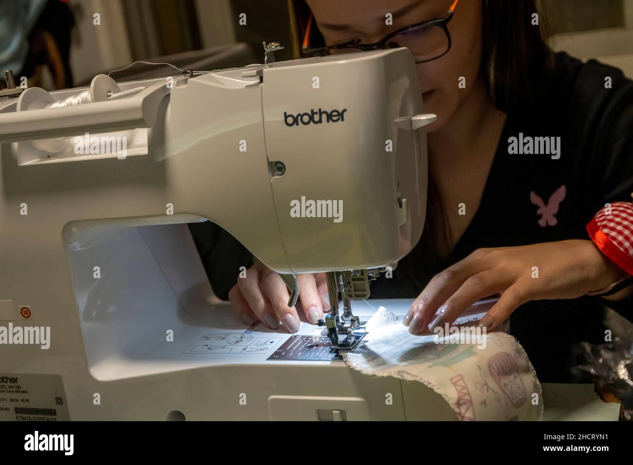 Donna cinese che usa una nuova macchina da cucire computerizzata, Hong Kong, Cina. Foto Stock