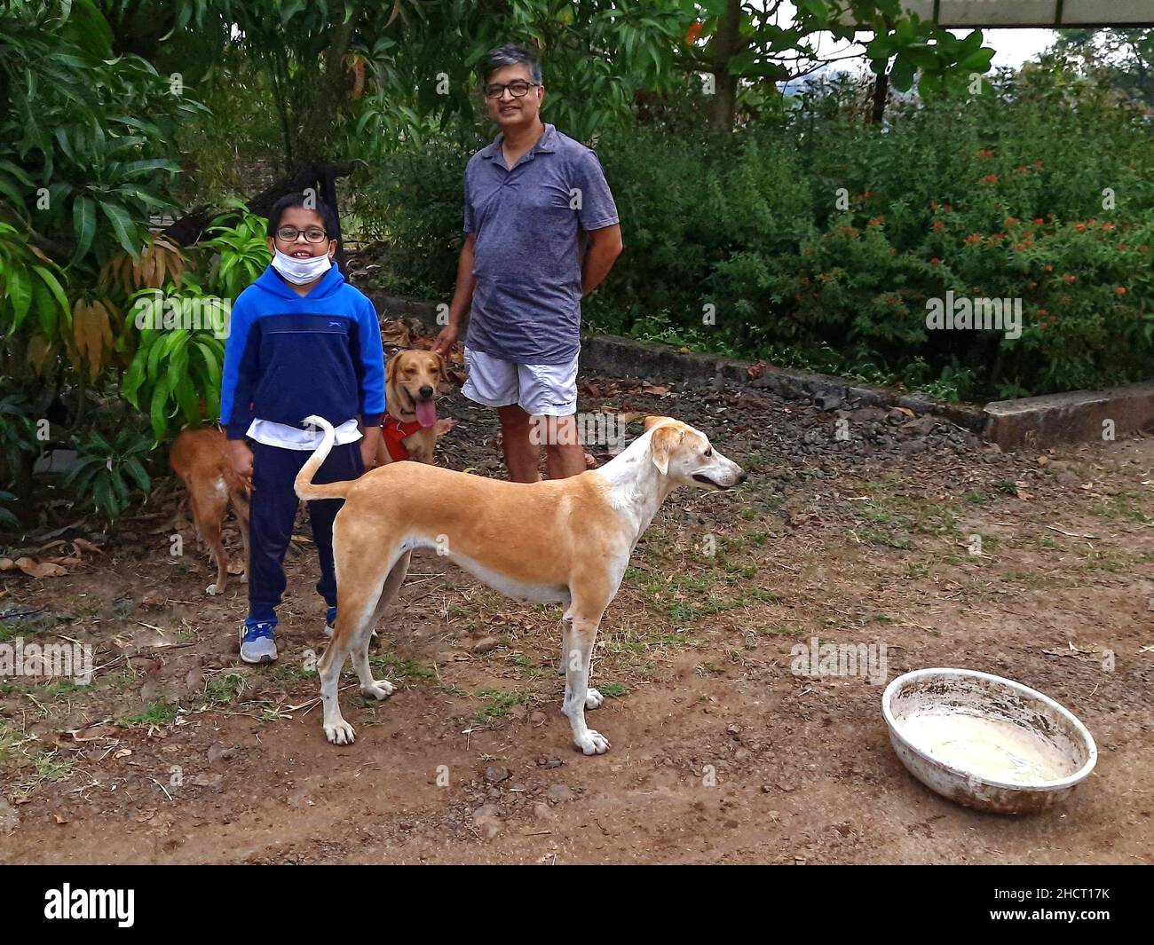 Padre e figlio con i loro cani in giardino Foto Stock