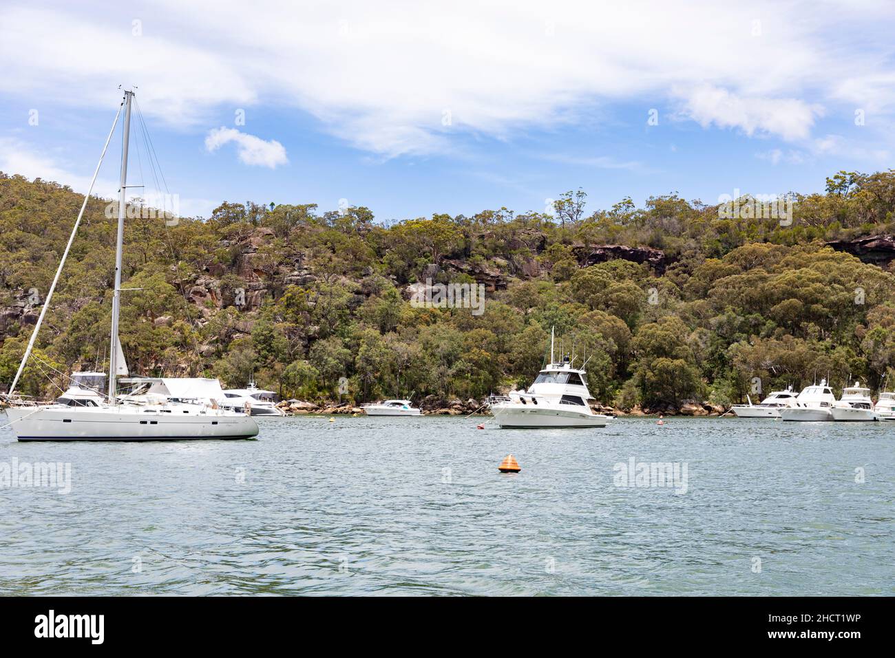Rifugio Bay, Cowan Creek sul fiume Hawkesbury con barche a motore e yacht a vela ormeggiati su boe in Refuge Bay durante l'estate, Sydney, Australia Foto Stock