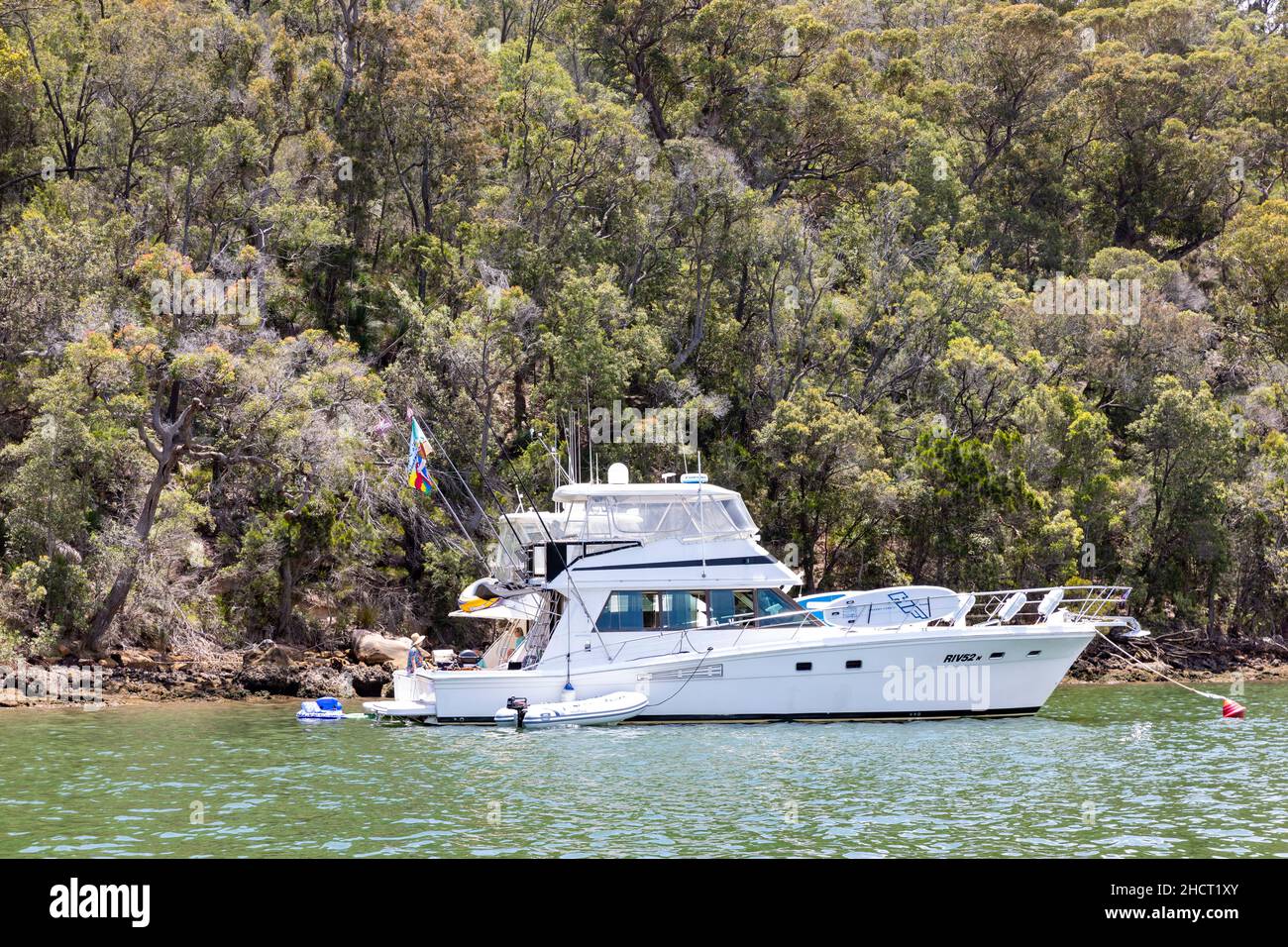 Riviera flybridge Yacht a motore ormeggiato su una boa in Refuge Bay, Hawkesbury River, Sydney, Australia Foto Stock