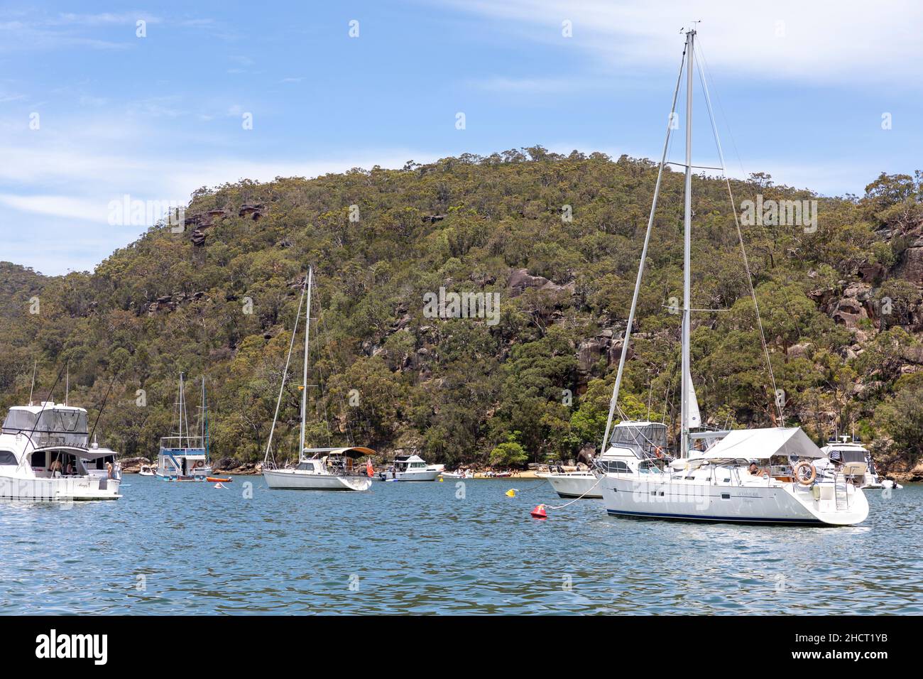 Rifugio Bay, Cowan Creek sul fiume Hawkesbury con barche a motore e yacht a vela ormeggiati su boe in Refuge Bay durante l'estate, Sydney, Australia Foto Stock