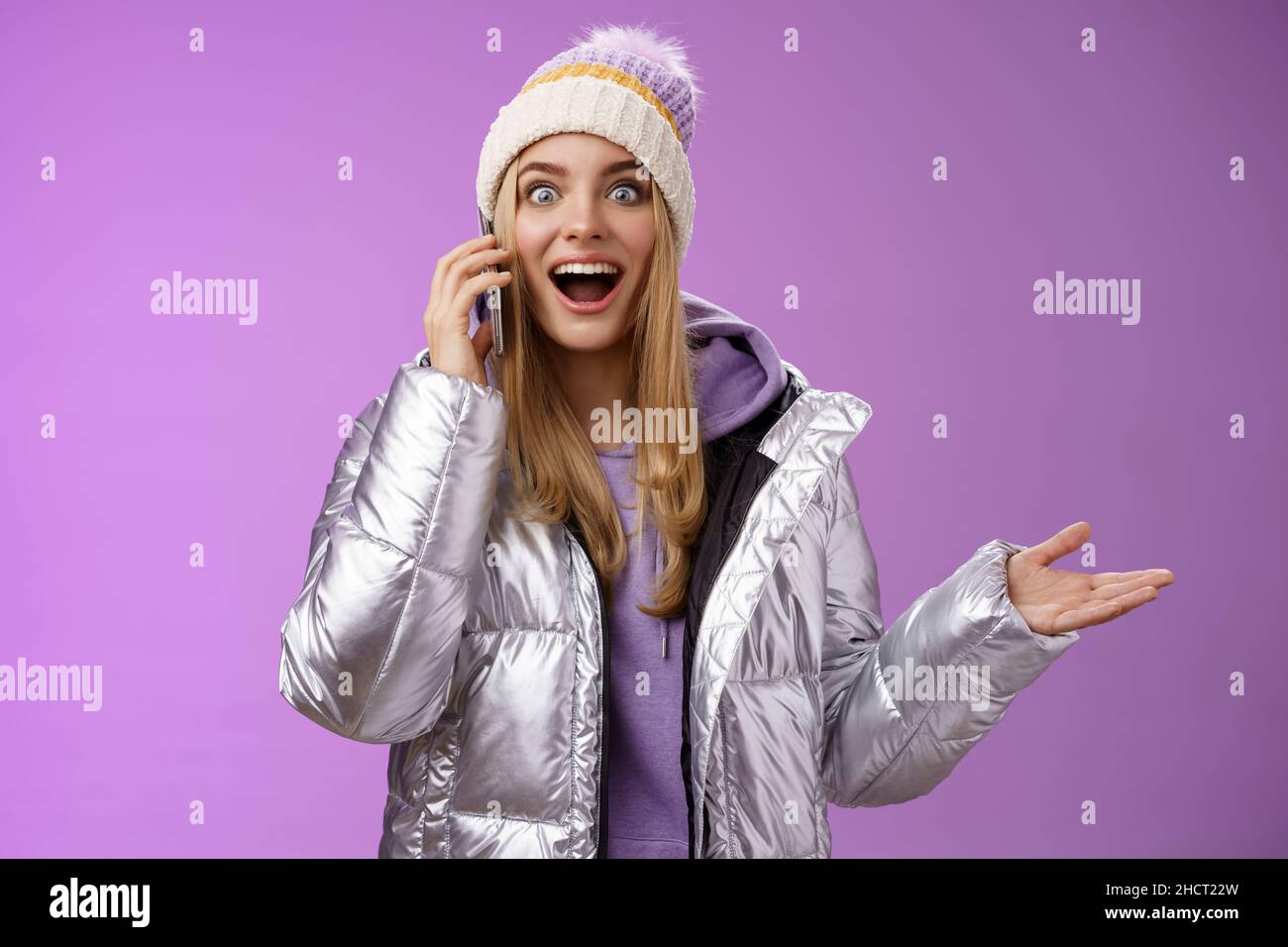 Talkative Amused bionda ragazza sentire impressionante buona notizia alzare mano sorpreso felice parlare smartphone allargare gli occhi soddisfatto perfetto informazioni, in piedi Foto Stock