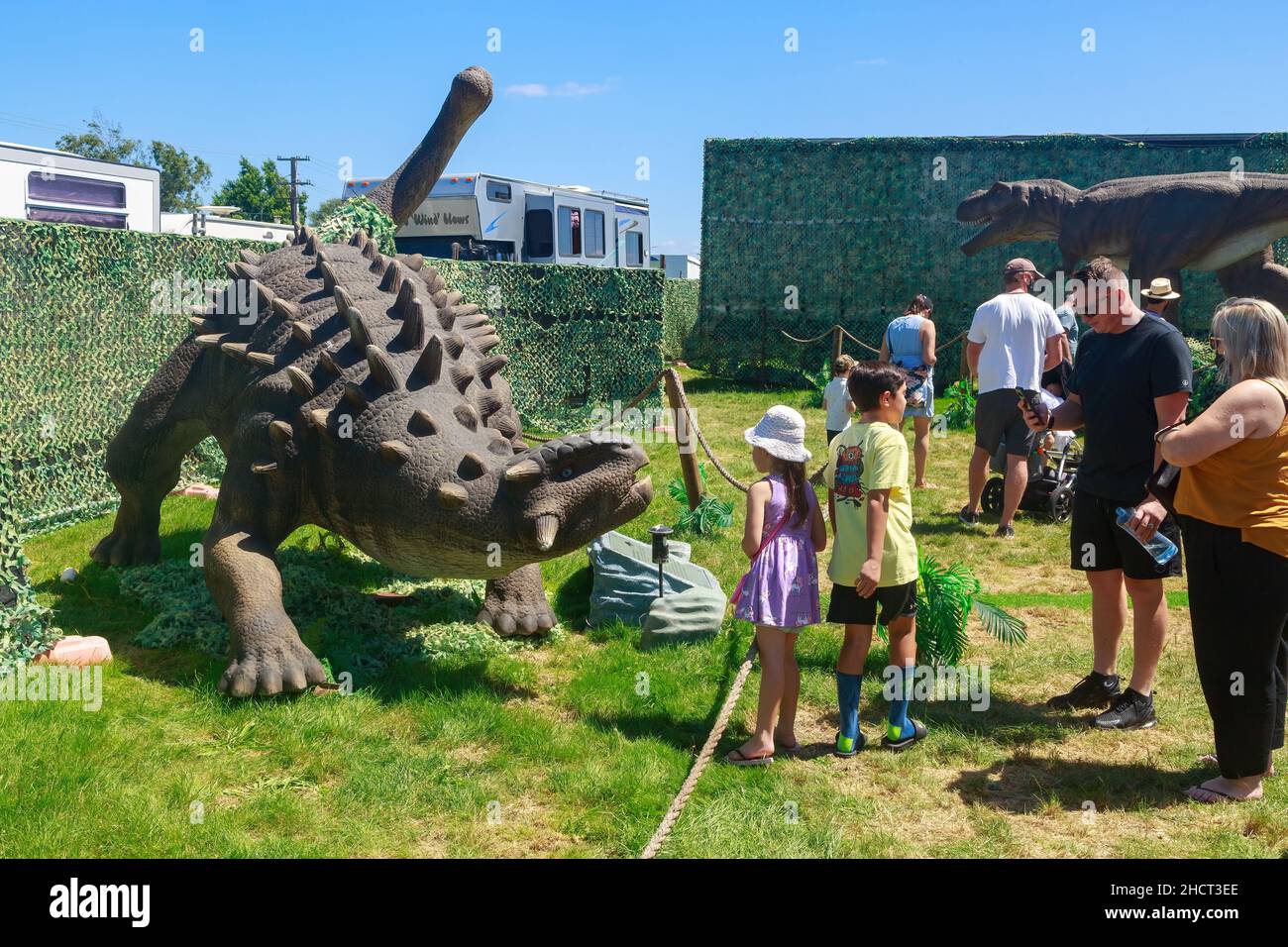 La gente guarda una scultura a grandezza naturale del dinosauro Ankylosaurus in uno spettacolo itinerante di dinosauri Foto Stock