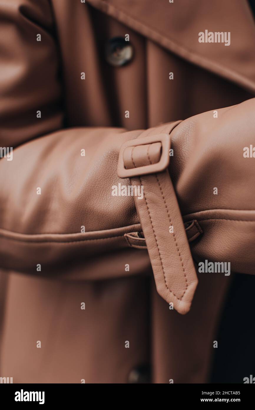 Primo piano dettagli di moda di un cappotto in pelle marrone autunnale con cinturino. Abito femminile Street style Foto Stock