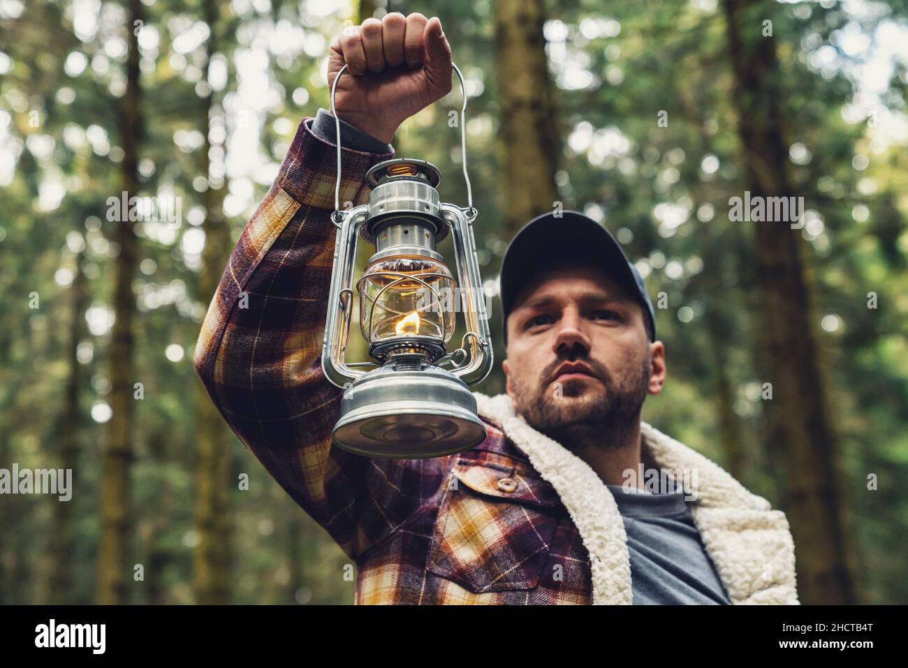 Uomo mano che tiene la lanterna a gas nella foresta profonda Foto Stock