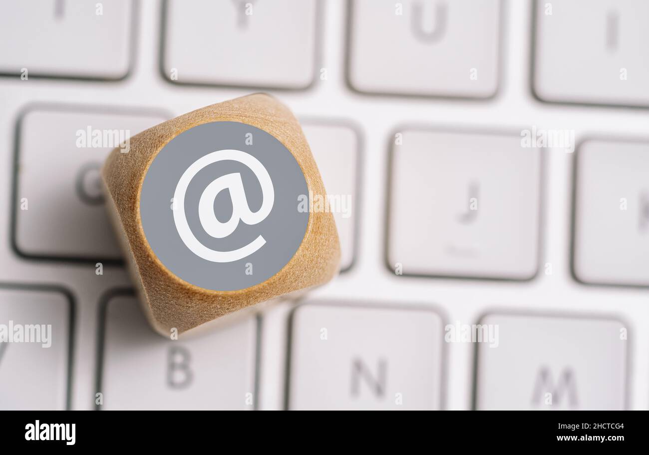 Invia un'e-mail all'icona su un cubo di legno su una tastiera. Immagine concettuale dei metodi di contatto e comunicazione Foto Stock