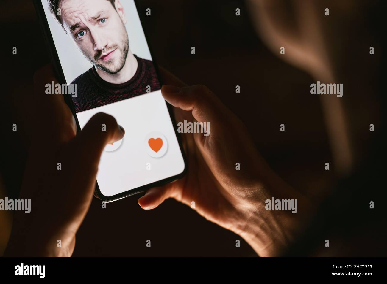 Donna che vuole fare foto sui social media o scorrere l'app di incontri online. Premere con il dito l'icona del cuore sullo schermo nell'applicazione per smartphone. Amico, f Foto Stock