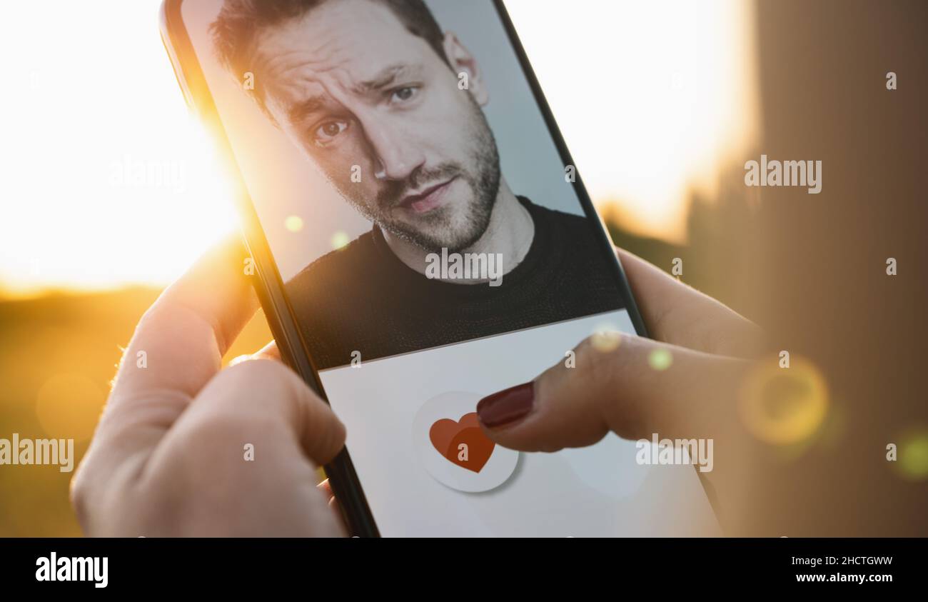 App di incontri sullo schermo del telefono cellulare. Donna che passa e ama i profili sul sito di relazione o applicazione. Donna singola che usa lo smartphone per trovare l'amore, Foto Stock