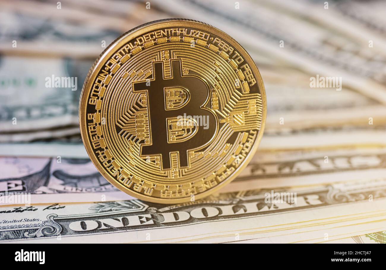 Golden Bitcoin sulla banconota da dollari USA. Concetto di cambio di valuta elettronico Foto Stock