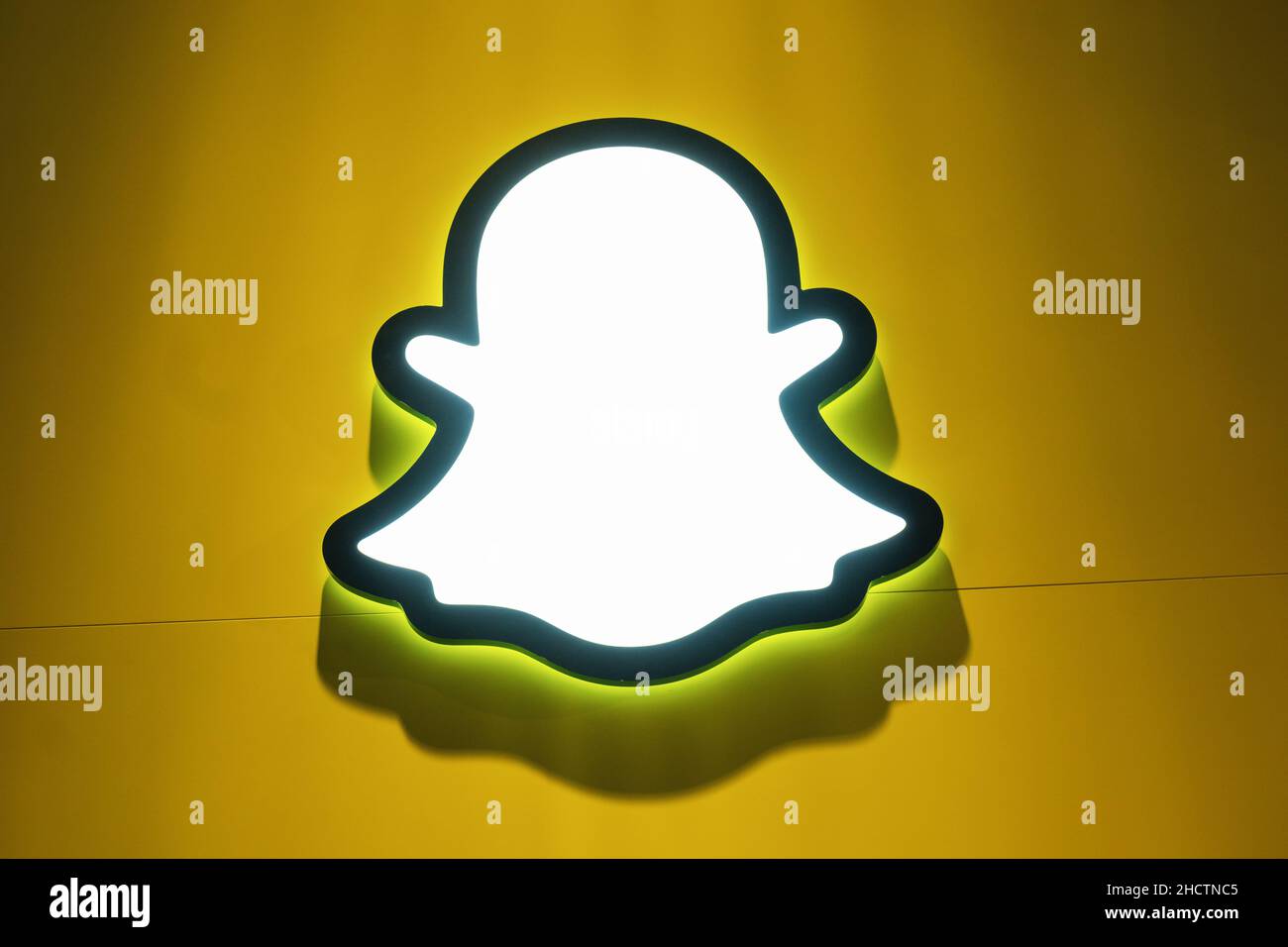 Logo Snapchat con arcobaleno stampato su una parete di carta. Snapchat è un'applicazione di social media molto diffusa per la condivisione di messaggi, immagini e video. Foto Stock