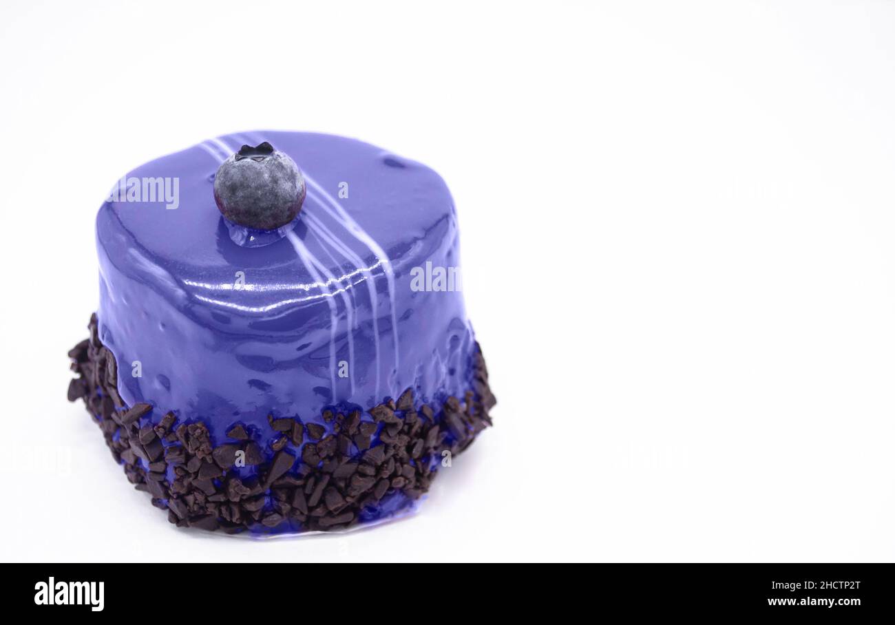 Primo piano torta di mousse molto colore pery con mirtillo e gocce di cioccolato su uno sfondo bianco. Spazio di copia. Foto Stock