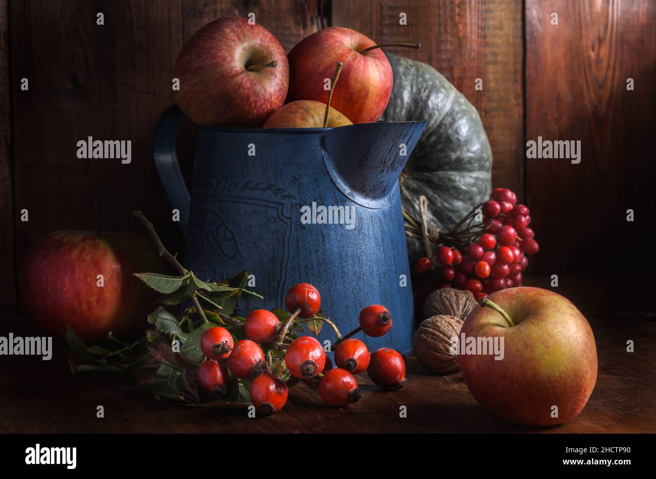mele in una brocca da giardino su sfondo di legno scuro in stile rustico Foto Stock
