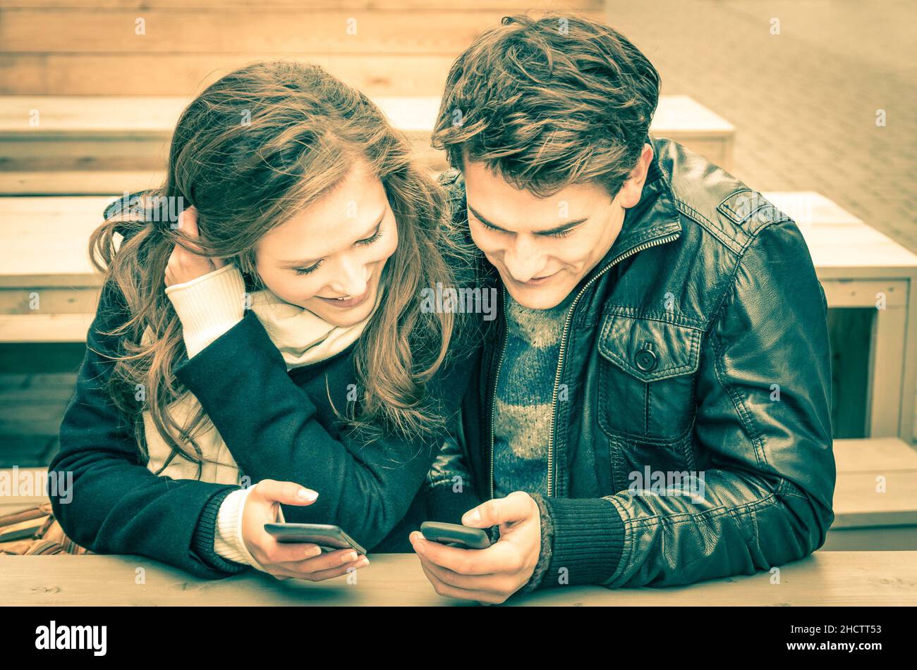 Coppia in amore divertirsi con i telefoni moderni Foto Stock