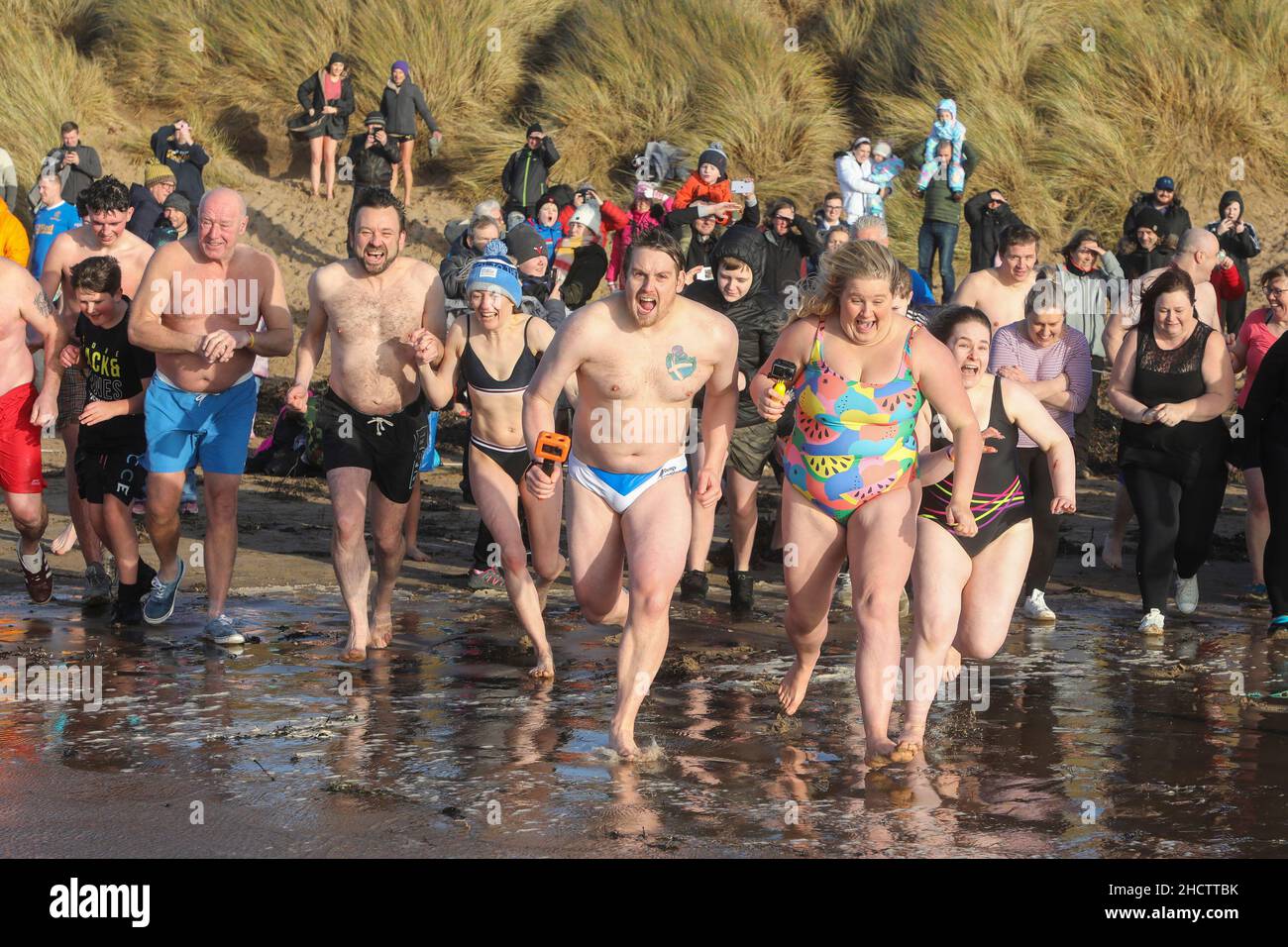 Irvine, Regno Unito. 1st Jan 2022. Più di 150 nuotatori hanno preso parte all'annuale Loony Dook nuotare al largo della spiaggia di Irvine a temperature marine inferiori a 9C. Molti dei nuotatori che hanno preso parte alla raccolta fondi per enti di beneficenza locali e nazionali Credit: Findlay/Alamy Live News Foto Stock