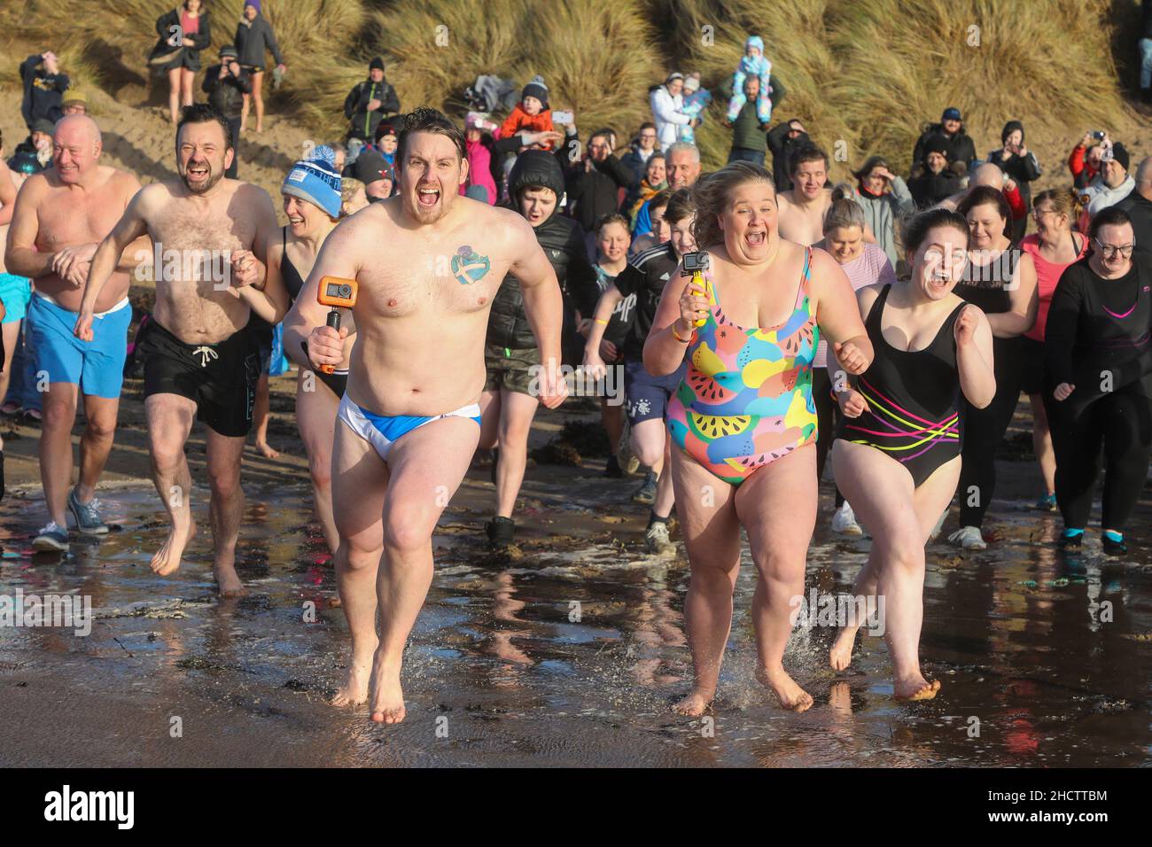 Irvine, Regno Unito. 1st Jan 2022. Più di 150 nuotatori hanno preso parte all'annuale Loony Dook nuotare al largo della spiaggia di Irvine a temperature marine inferiori a 9C. Molti dei nuotatori che hanno preso parte alla raccolta fondi per enti di beneficenza locali e nazionali Credit: Findlay/Alamy Live News Foto Stock