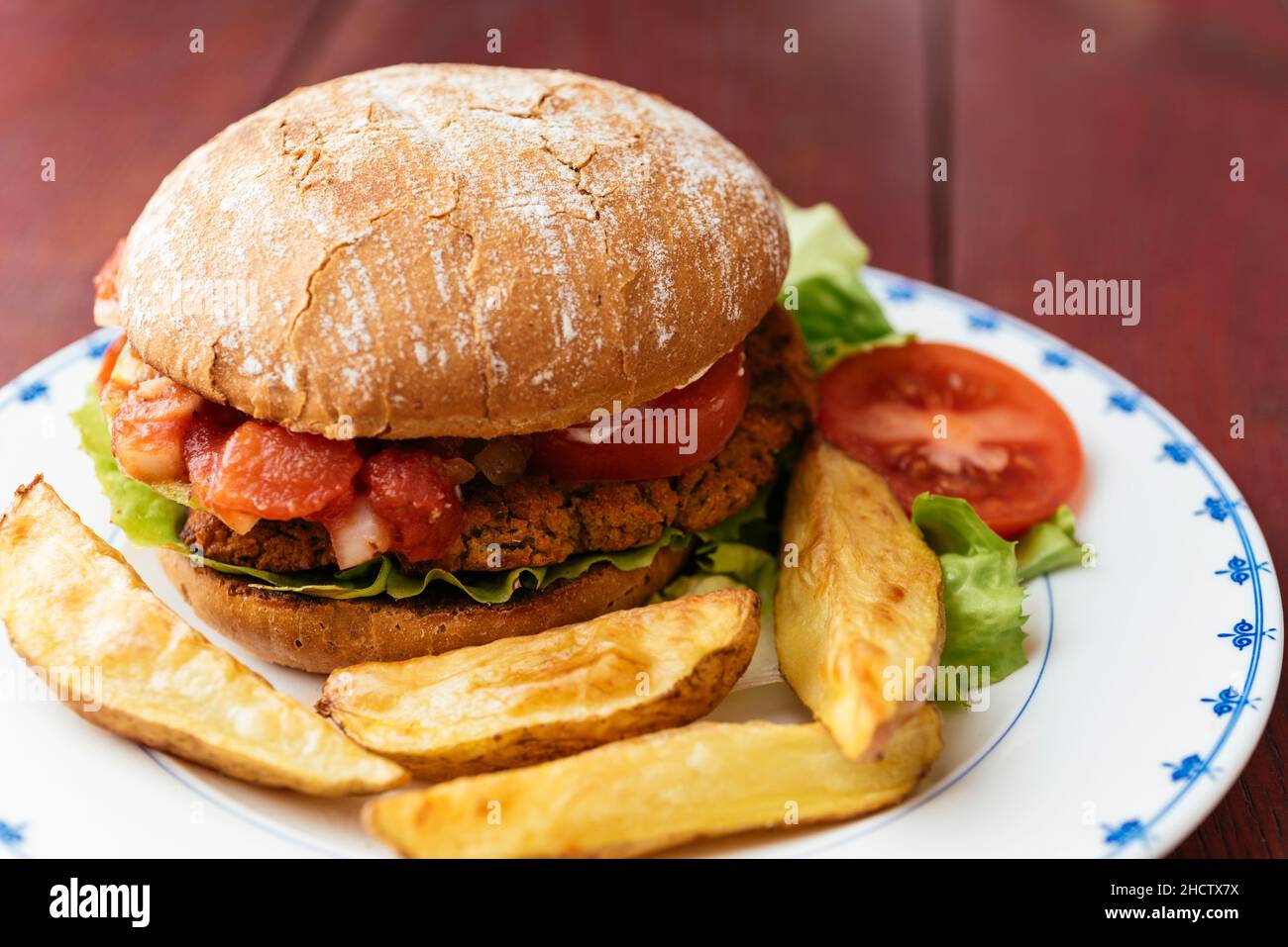 Hamburger di verdure vegane fatto in casa con patatine fritte. Foto Stock