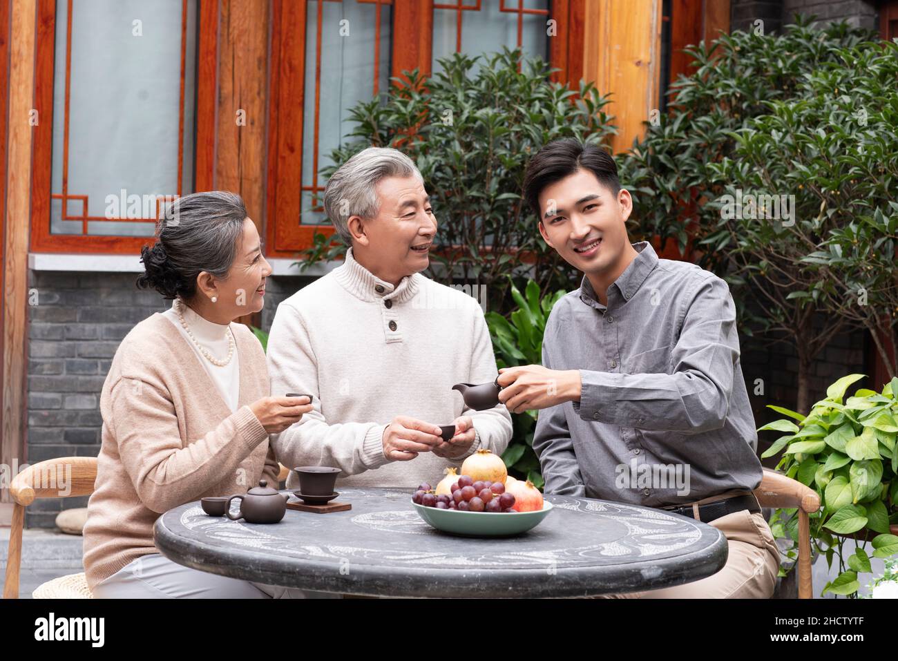 Famiglie felici che bevono il tè e chiacchierano nel cortile Foto Stock