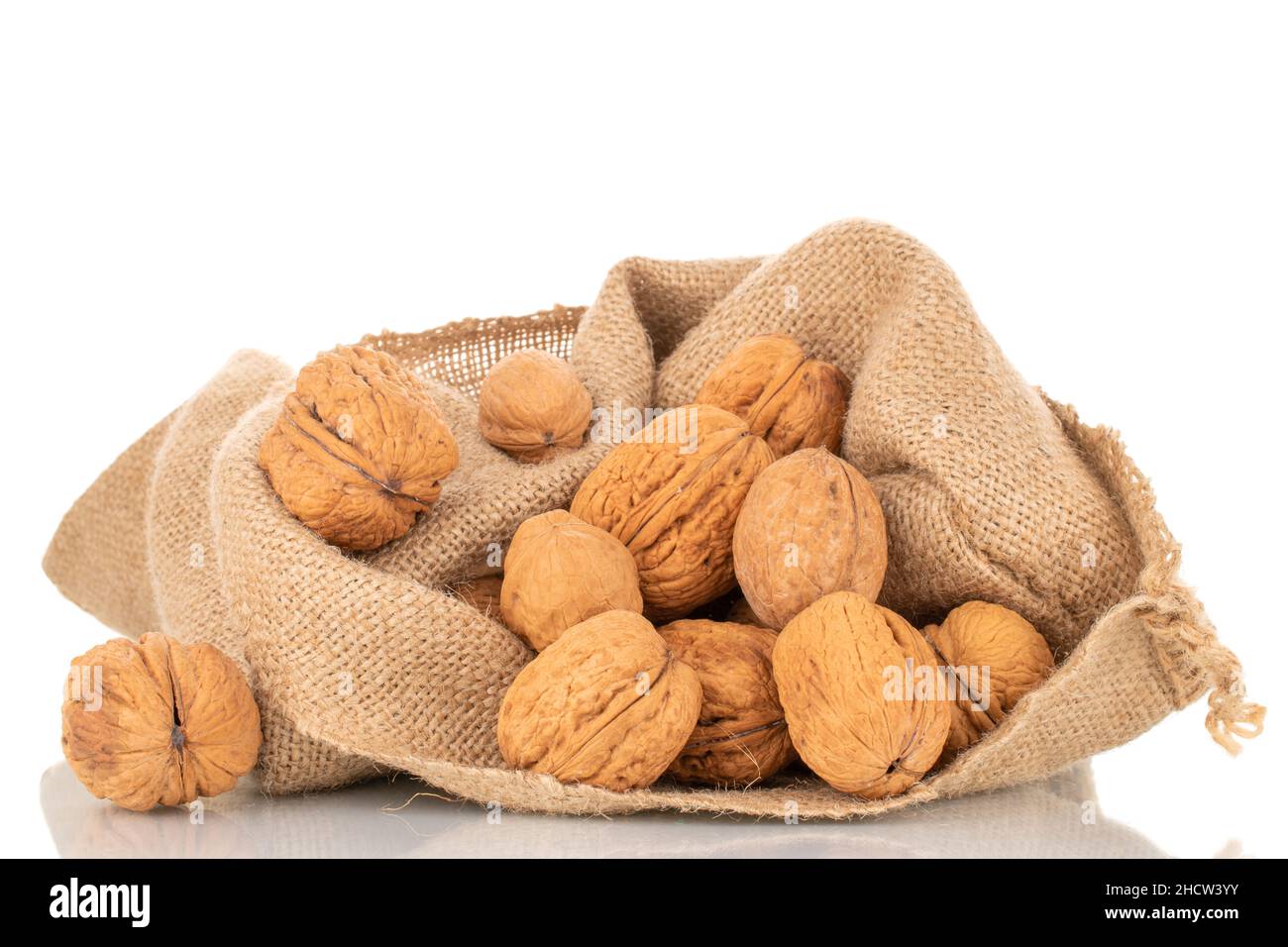 Diverse noci mature in una borsa di iuta, primo piano, isolato su bianco. Foto Stock