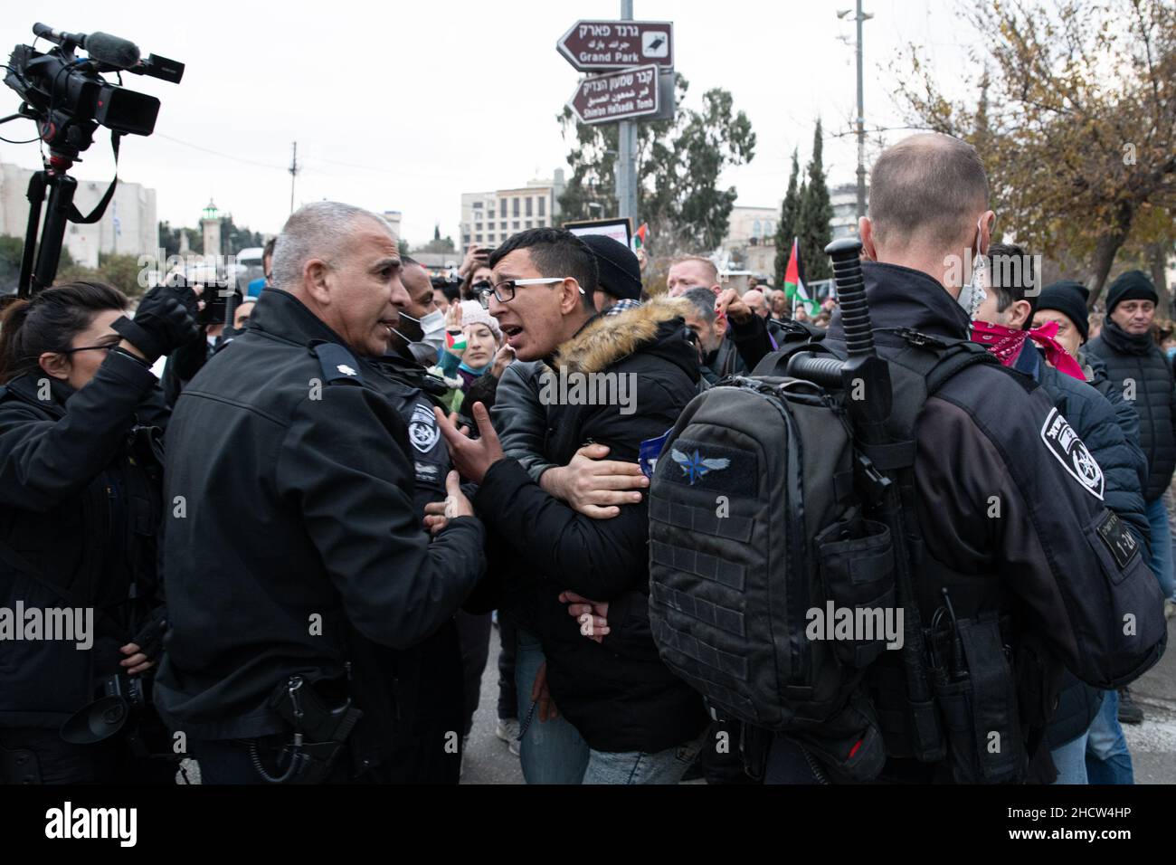 Scontri durante la protesta di solidarietà a Sheikh Jarrah contro la deportazione di famiglie palestinesi dal nigberhood. Si sono verificati scontri tra la polizia israeliana e i manifestanti per aver sventolato la bandiera palestinese. Un giovane palestinese è stato arrestato per aver sventurato la bandiera sulla strada principale. Una settimana fa, il parcheggio di un autobus era chiuso dopo aver ricevuto un ordine di sfratto. Gerusalemme, Israele. 31th dicembre 2021. (Matan Golan/Sipa USA) Foto Stock