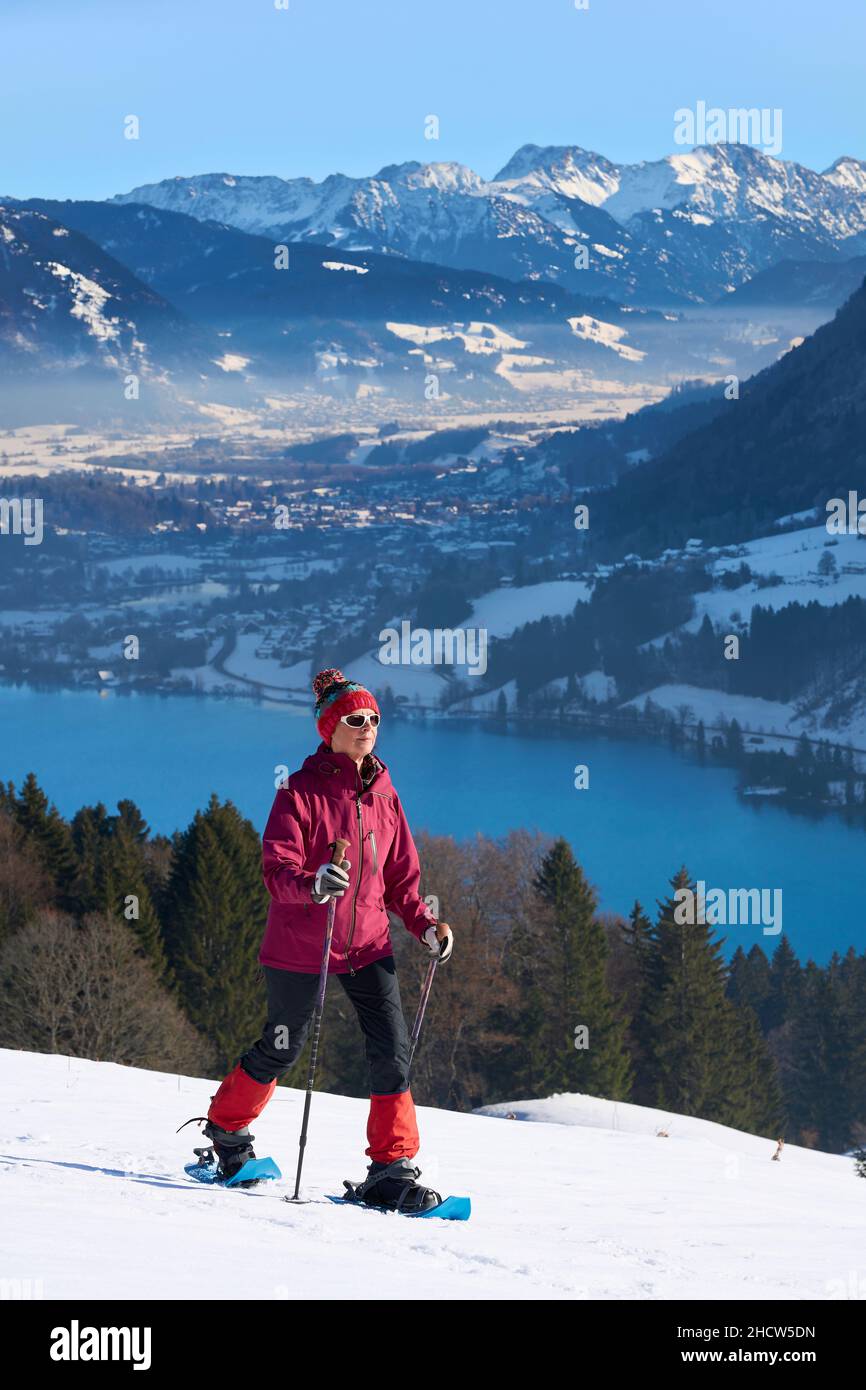Donna anziana, molto attiva e simpatica, con racchette da neve nelle alpi di Allgau, sopra il lago Alpsee e Immenstadt, Baviera, Germania Foto Stock