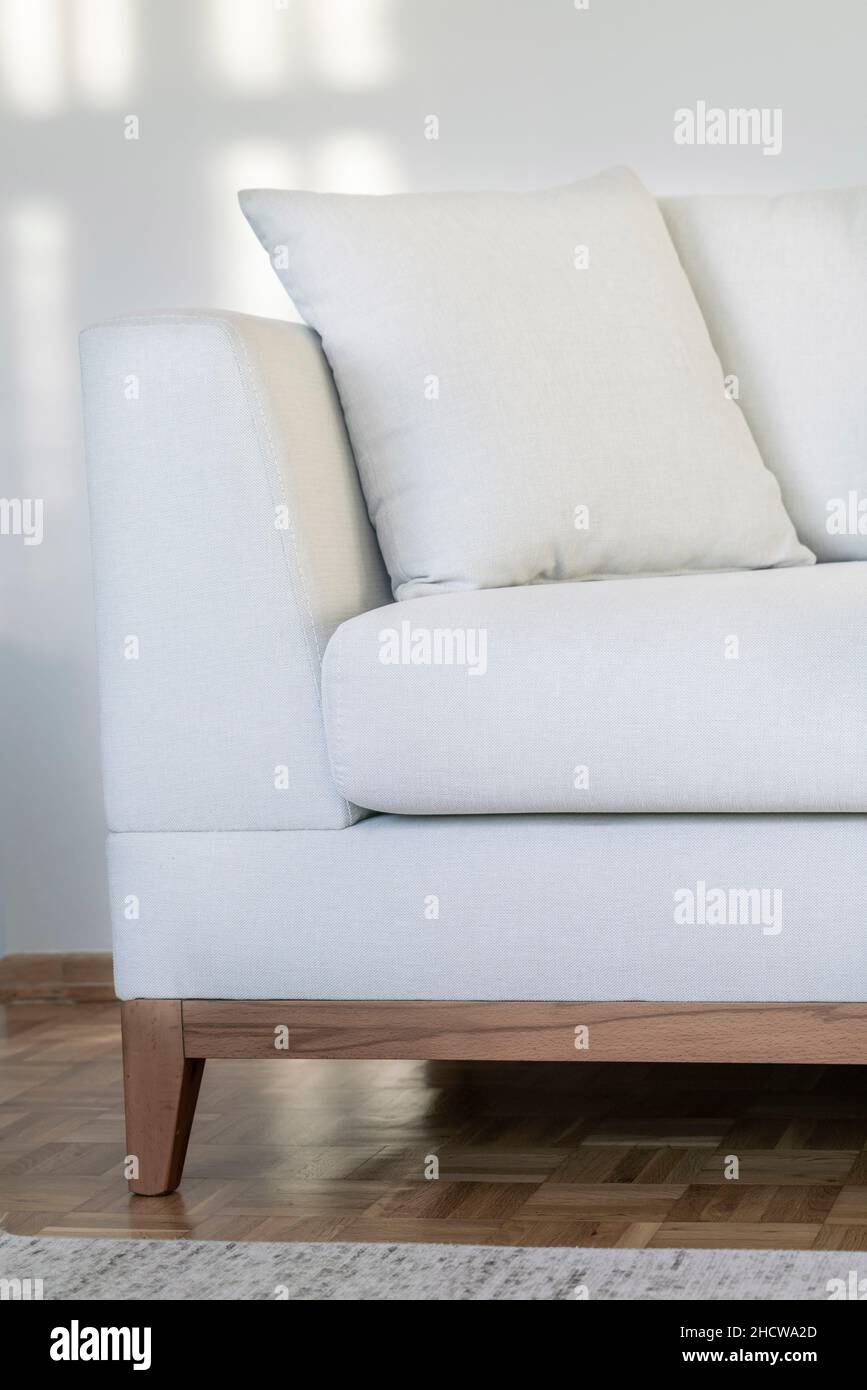 poltrona, cuscino per closeup su un divano o divano o poltrona in soggiorno. parete con finestra a riflessione per via del sole, interno della casa Foto Stock