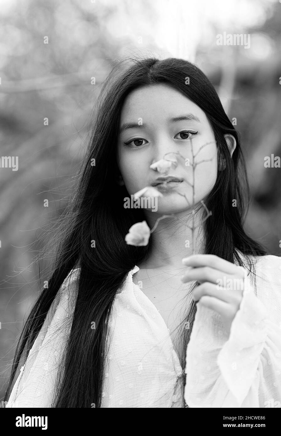 Adolescente cinese con un fiore in mano III Foto Stock