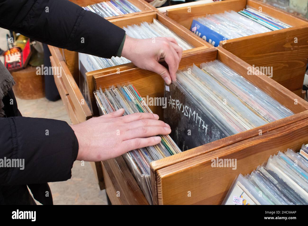 Lviv, Ucraina - 7 marzo 2021 : un uomo che acquista dischi vinilici vintage sul mercato delle pulci o sulla vendita di garage. Scatole in legno con dischi singoli in vinile retrò, selec Foto Stock