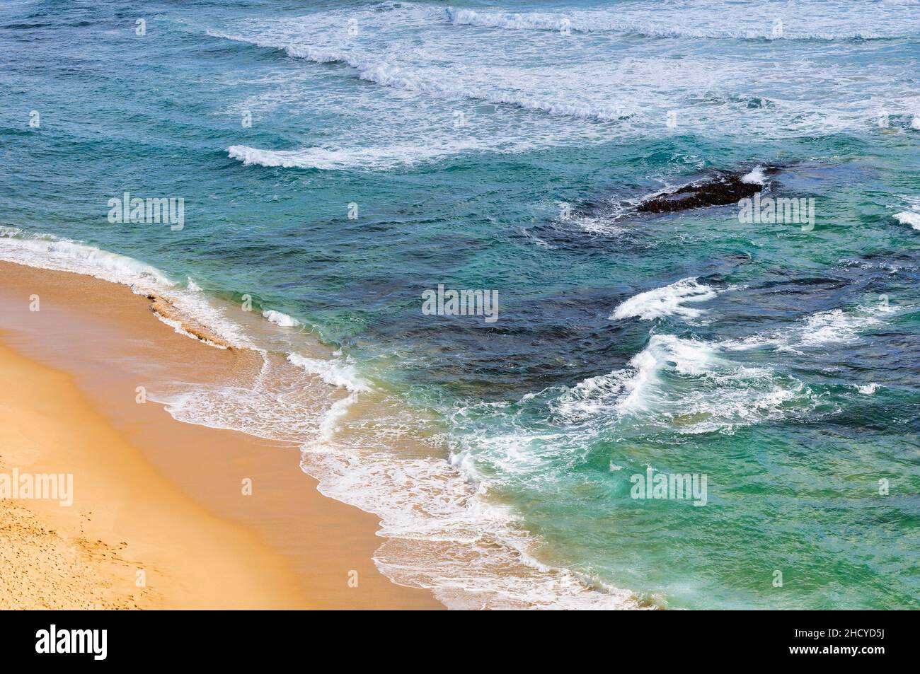 Dolci onde lavare la spiaggia di sabbia a Gibson Steps - Port Campbell, Victoria, Australia Foto Stock