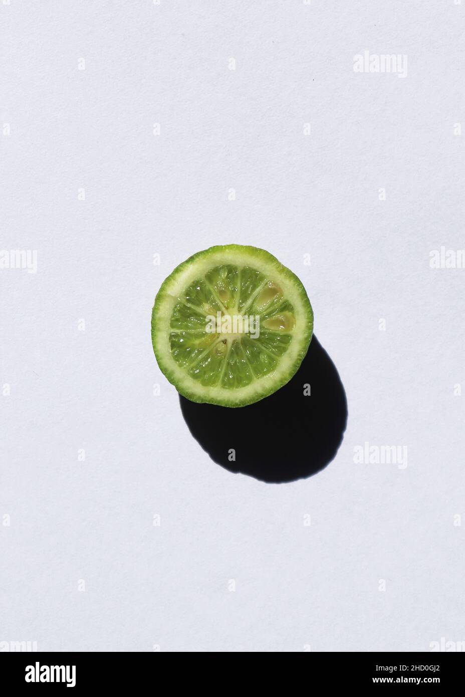 Una fetta di lime fresca su un bacgkround bianco Foto Stock