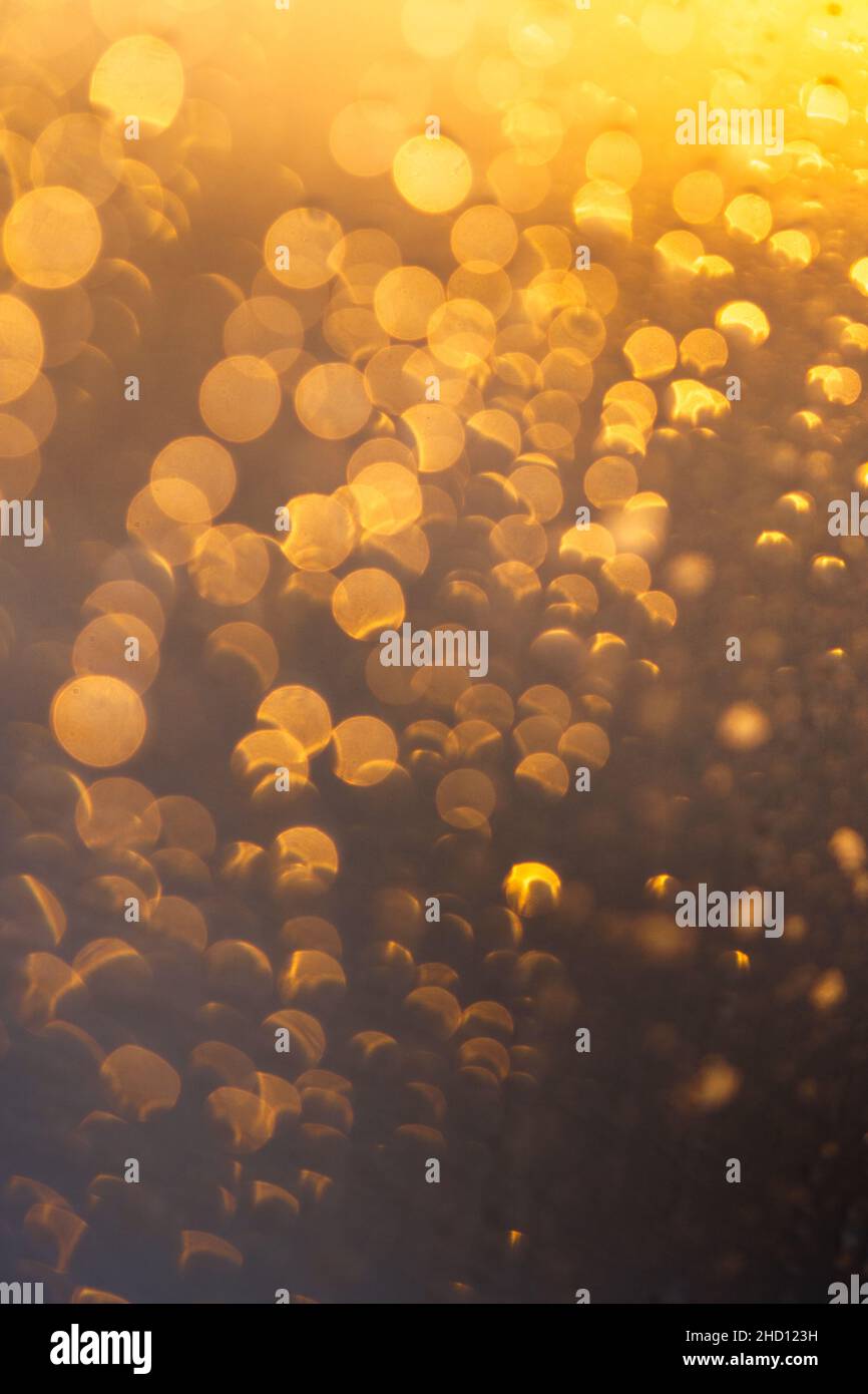 Astratto oro circolare e arancio bokeh luce solare riflesso vetro della finestra. Pioggia gocce texture. Foto Stock