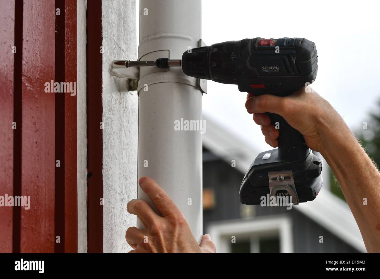 Un uomo che usa una macchina del cacciavite per migliorare la casa Foto Stock