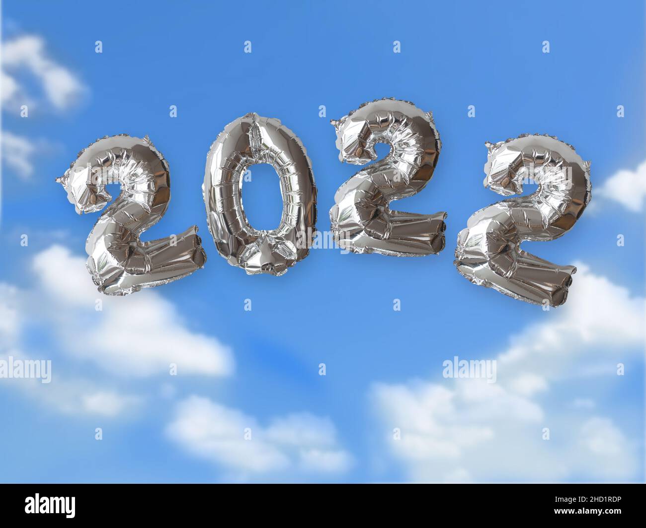 Anno 2022 scritto con i numeri di palloncino metallico d'argento che galleggiano nell'aria con il cielo blu e le nuvole di luce bianche. Concetto di prospettive per l'anno WIT Foto Stock