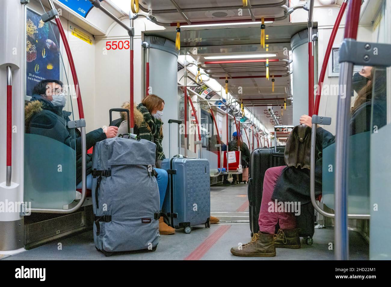Viaggiatori con bagagli all'interno di un treno della metropolitana TTC durante la pandemia di Coronavirus. Indossano maschere protettive. 2 gennaio 2022 Foto Stock