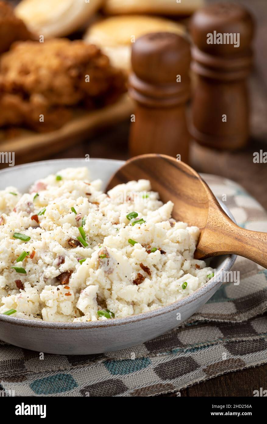 Ciotola di purè di patate con pezzi di pancetta e erba cipollina su un rustico tavolo di legno Foto Stock