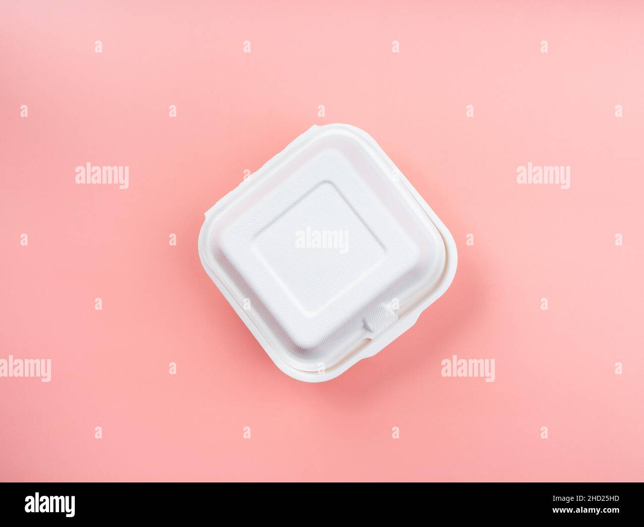 Scatola alimentare bianca in fibra vegetale non sbiancata isolata su sfondo rosa pastello, vista dall'alto. Contenitore per alimenti riciclabile e biodegradabile forma quadrata per il verde Foto Stock