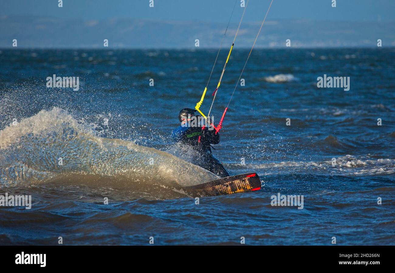 Longniddry, East Lothian, Scozia, Regno Unito. 2nd gennaio 2022. Vento guastato a 20 km/h con raffiche potenziali di 35 km/h temperatura di 8 gradi per i pochi kitesurfers che si avventurarono fuori sul Firth choppy di Forth. Le condizioni hanno dato un buon potenziale per i surfisti esperti per ottenere un po' di aria buona. Credito: Arch White Foto Stock